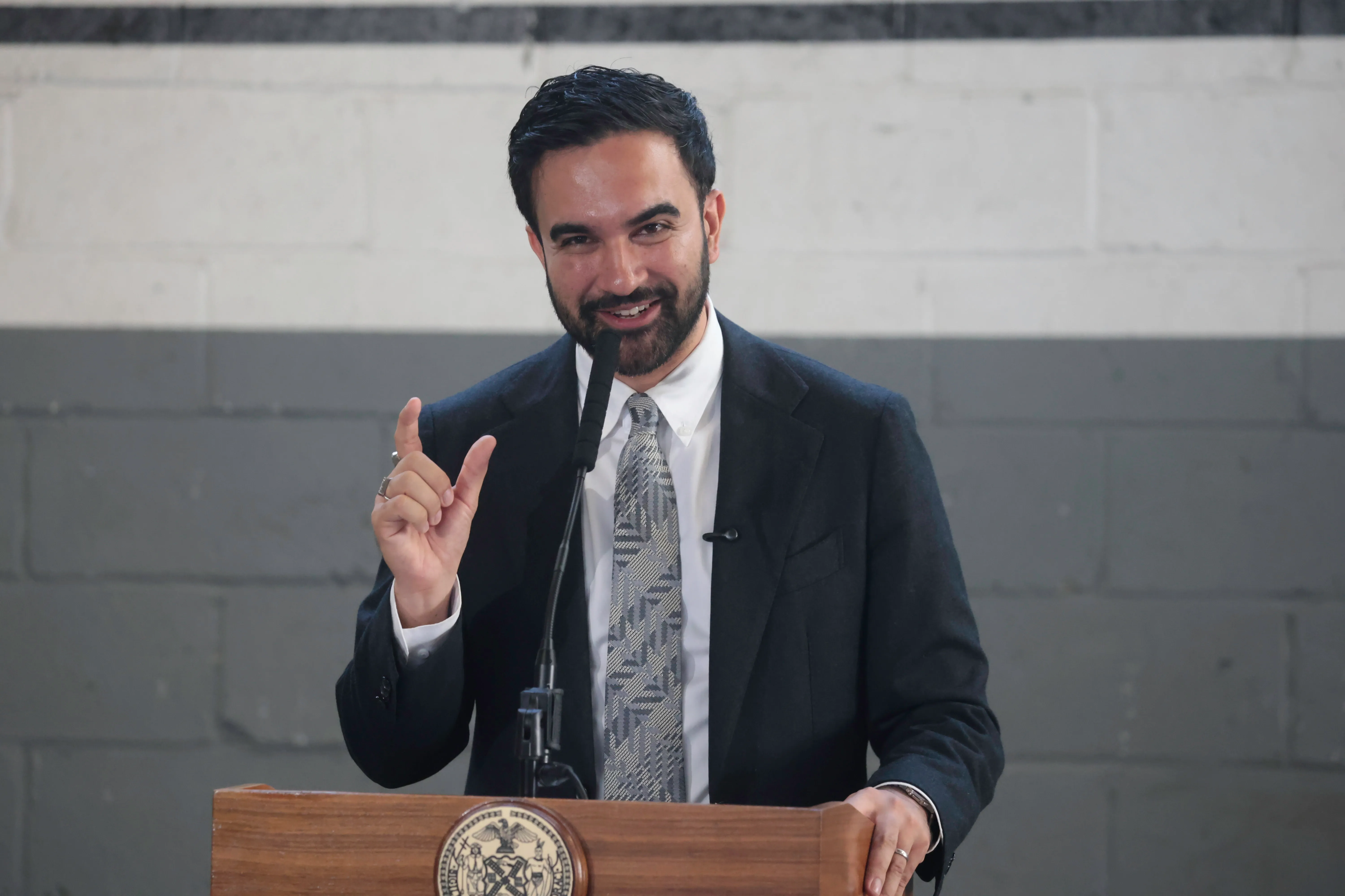 NYC Mayor Zohran Mamdani speaking at a podium.