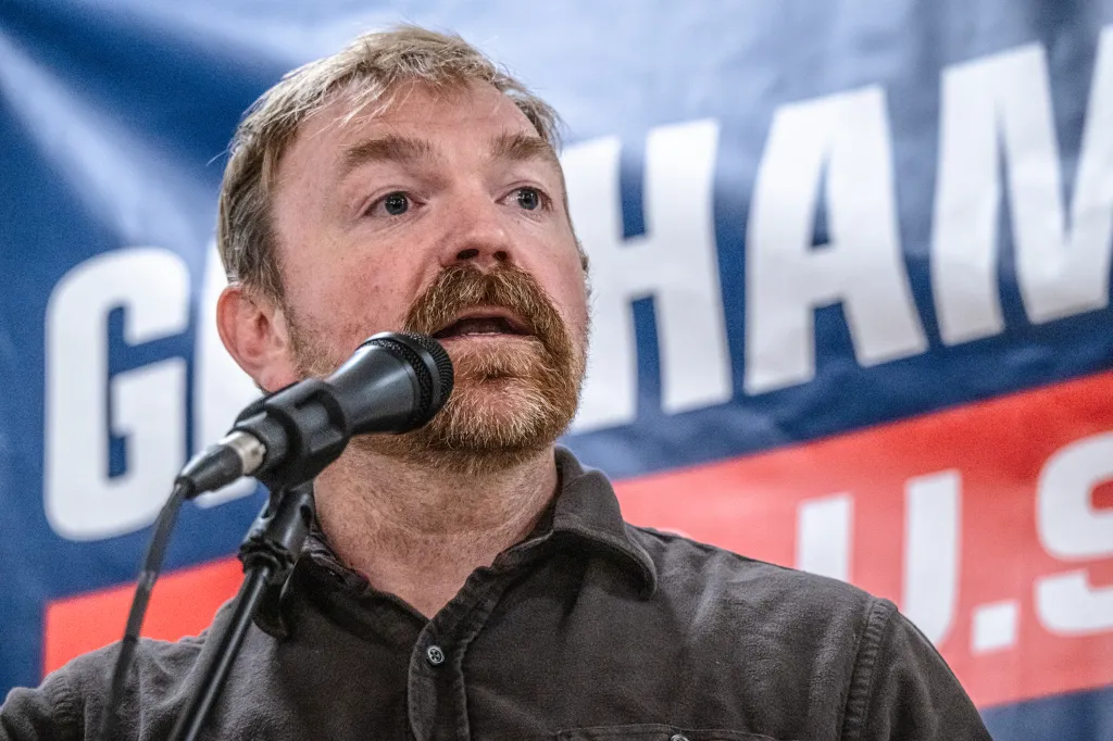 Democratic U.S. Senate candidate Graham Platner speaks into a microphone at a town hall.