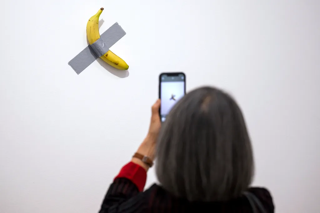 A visitor admiring Maurizio Cattelan's 