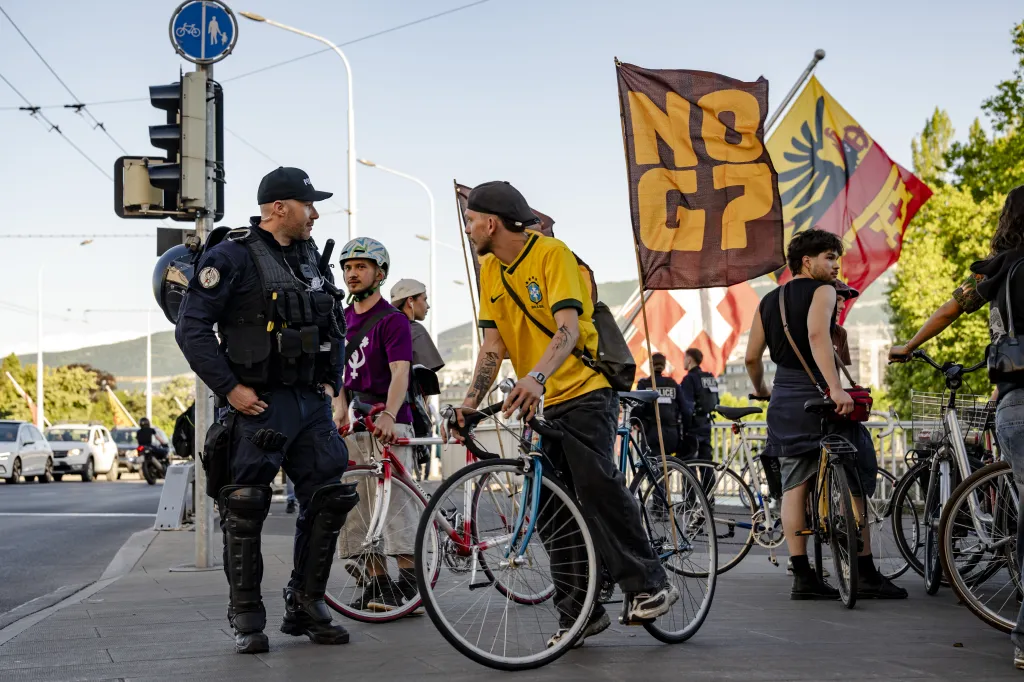 A police officer checking cyclists' identification during a Critical Mass No-G7 rally in Geneva.