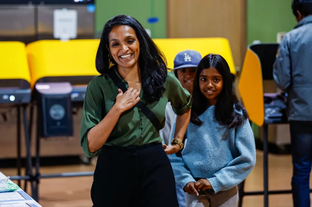 Los Angeles mayoral candidate Nithya Raman smiles while casting her ballot with children at a polling station.