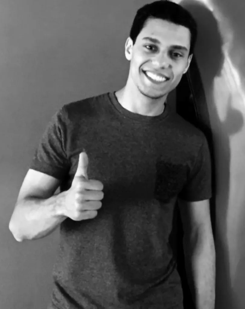 A man smiling and giving a thumbs up.