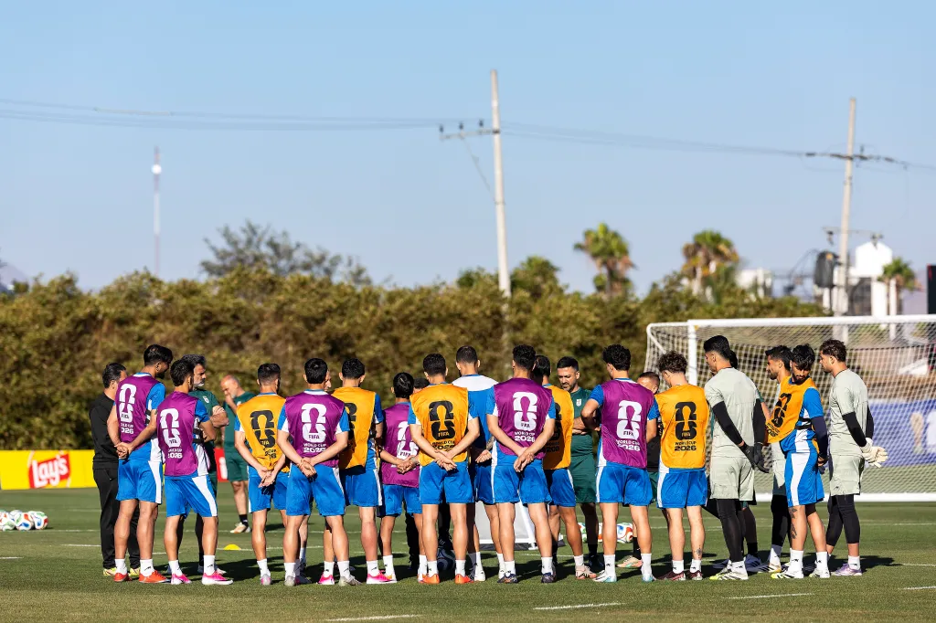 The IR Iran men's national football team stands in a huddle during a training session.