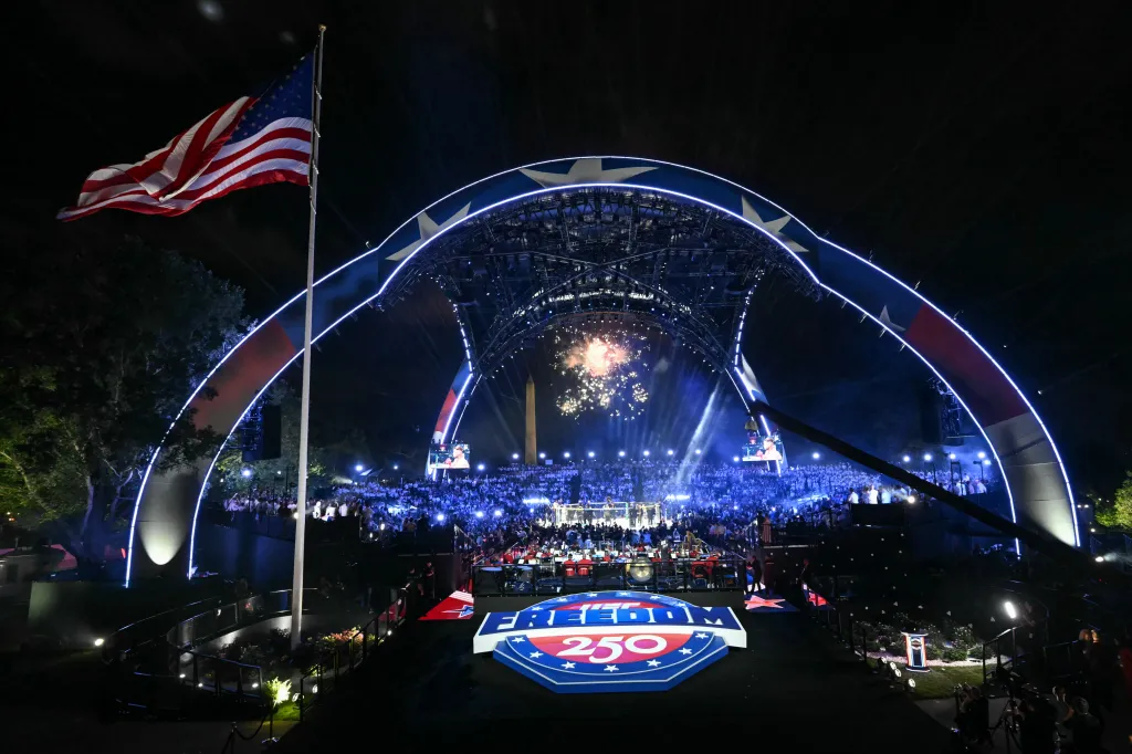 Fireworks illuminate the night sky above the UFC Freedom 250 event at the White House, with a large crowd in attendance and the Washington Monument in the background.