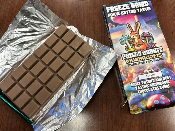 Psilocybin chocolate bar in foil next to its colorful 