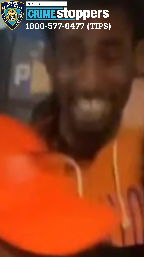A man in an orange jacket is seen smiling on the streets of Midtown during the brawl.
