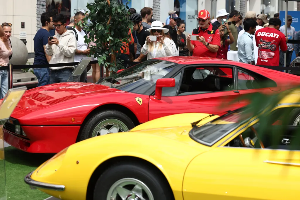Two classic Ferrari sports cars, one red and one yellow, on display at the 31st Annual Rodeo Drive Concours d’Elegance.