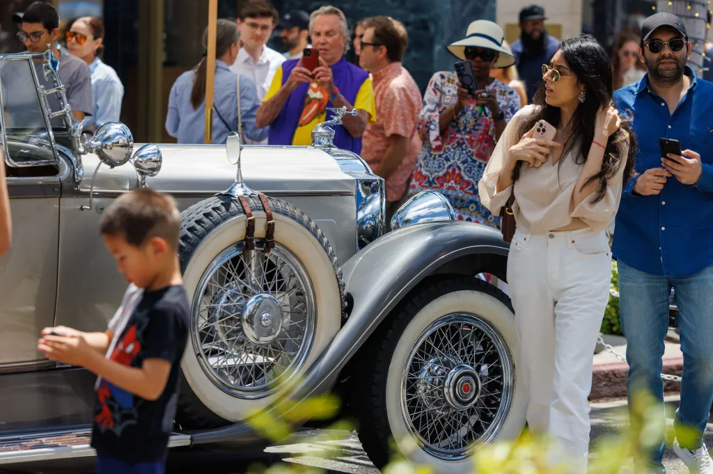 Attendees at the 31st Annual Rodeo Drive Concours d’Elegance admiring a classic car.
