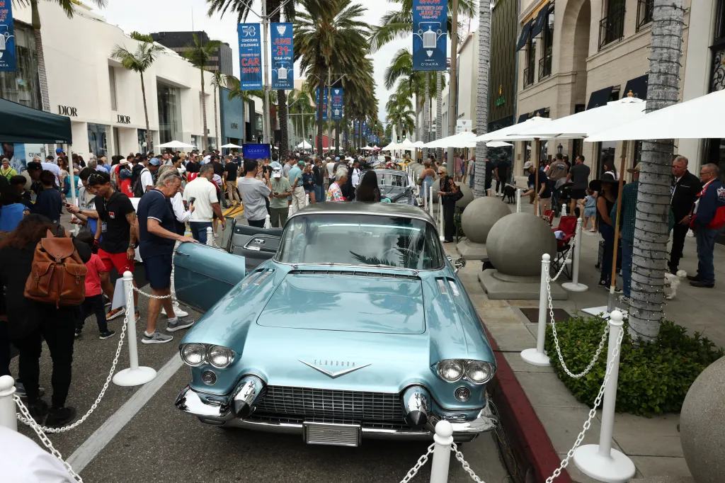A crowd gathers around a light blue classic Cadillac Eldorado on Rodeo Drive during the 31st Annual Rodeo Drive Concours d’Elegance.