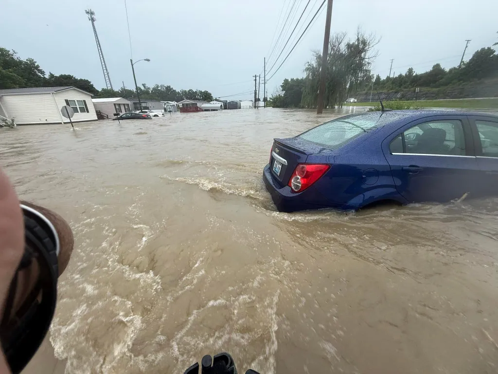 A parked car is surrounded by floodwaters on a street in Richmond, Kentucky, on June 27, 2026.