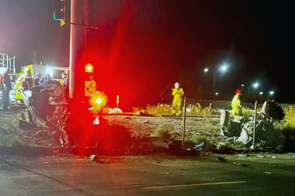 Nighttime scene of a fatal crash showing emergency personnel and debris from the vehicle that slammed into a traffic signal.