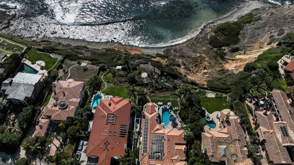 Aerial view of coastal erosion in Rancho Palos Verdes, California, where homes are built at the edge of a cliff.