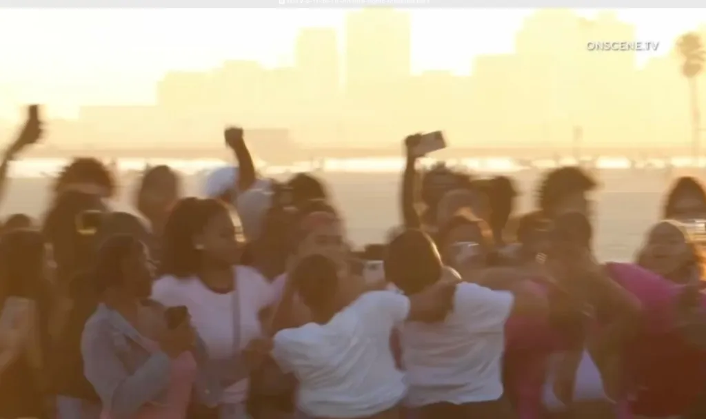 A group of juveniles fighting during sunset.