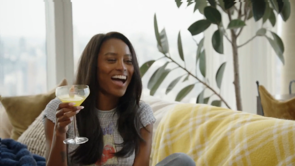 Woman laughing and holding a cocktail.