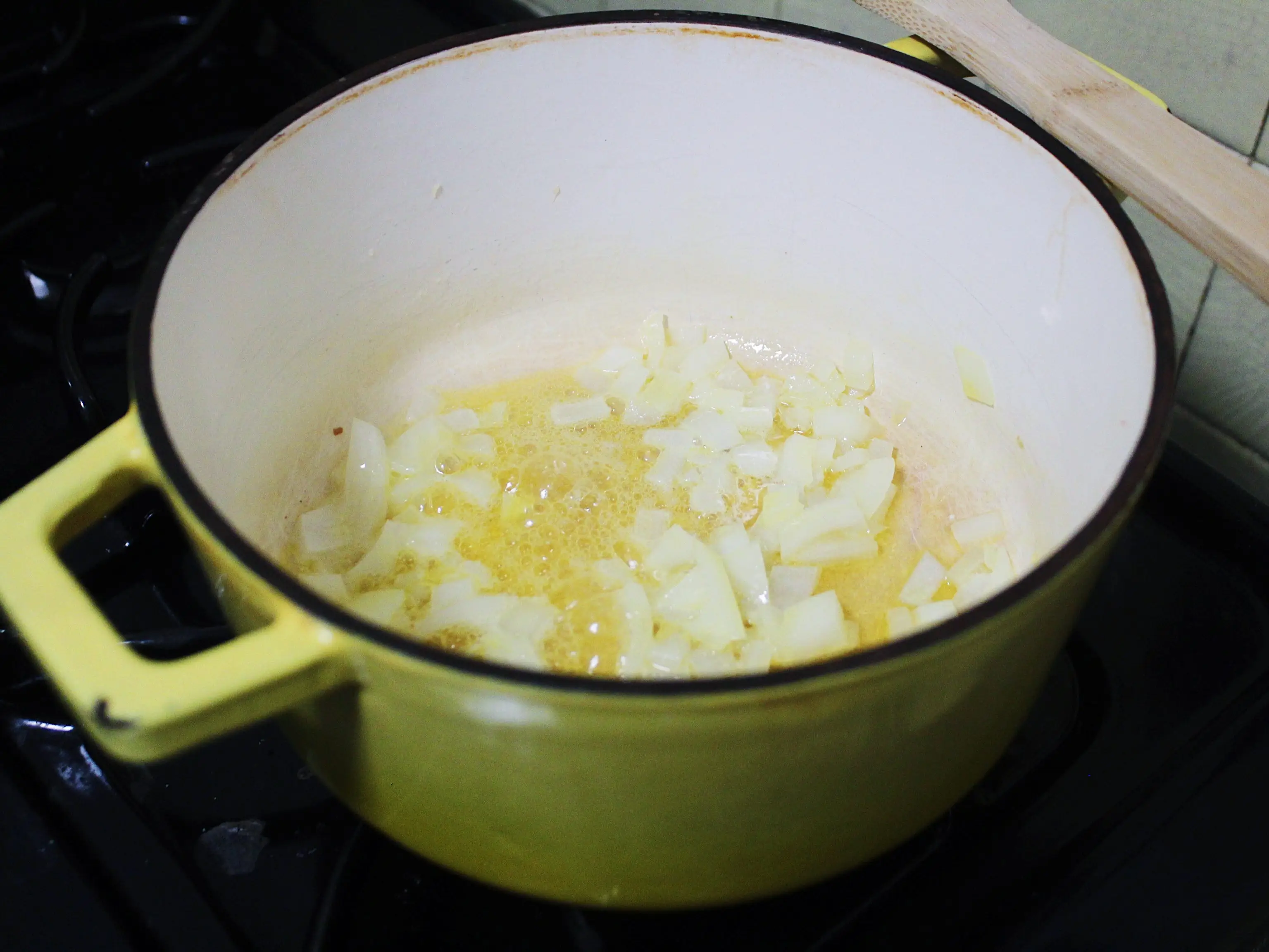 onions and butter in a yellow pot on a stove