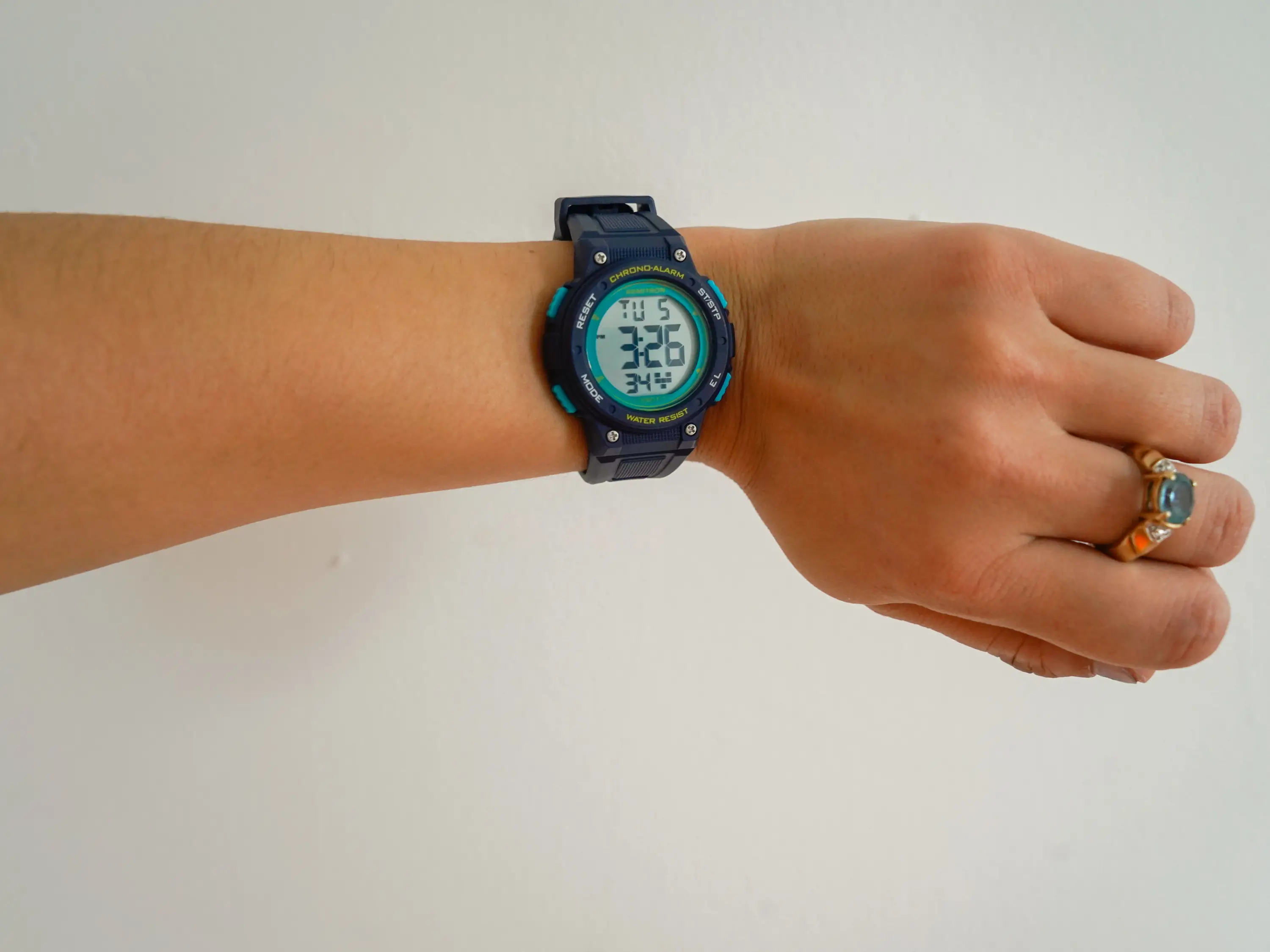 An arm wearing a digital watch