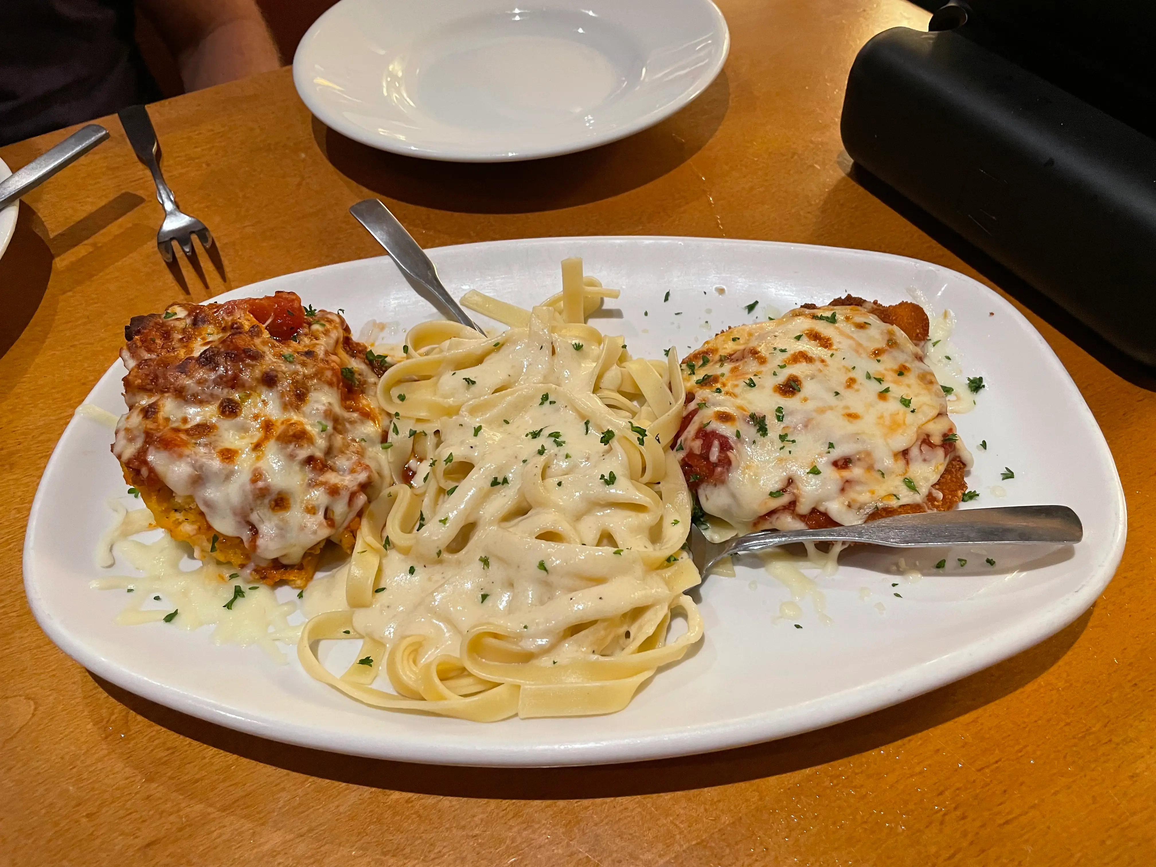 A plate of lasagna, pasta, and chicken Parmigiana.
