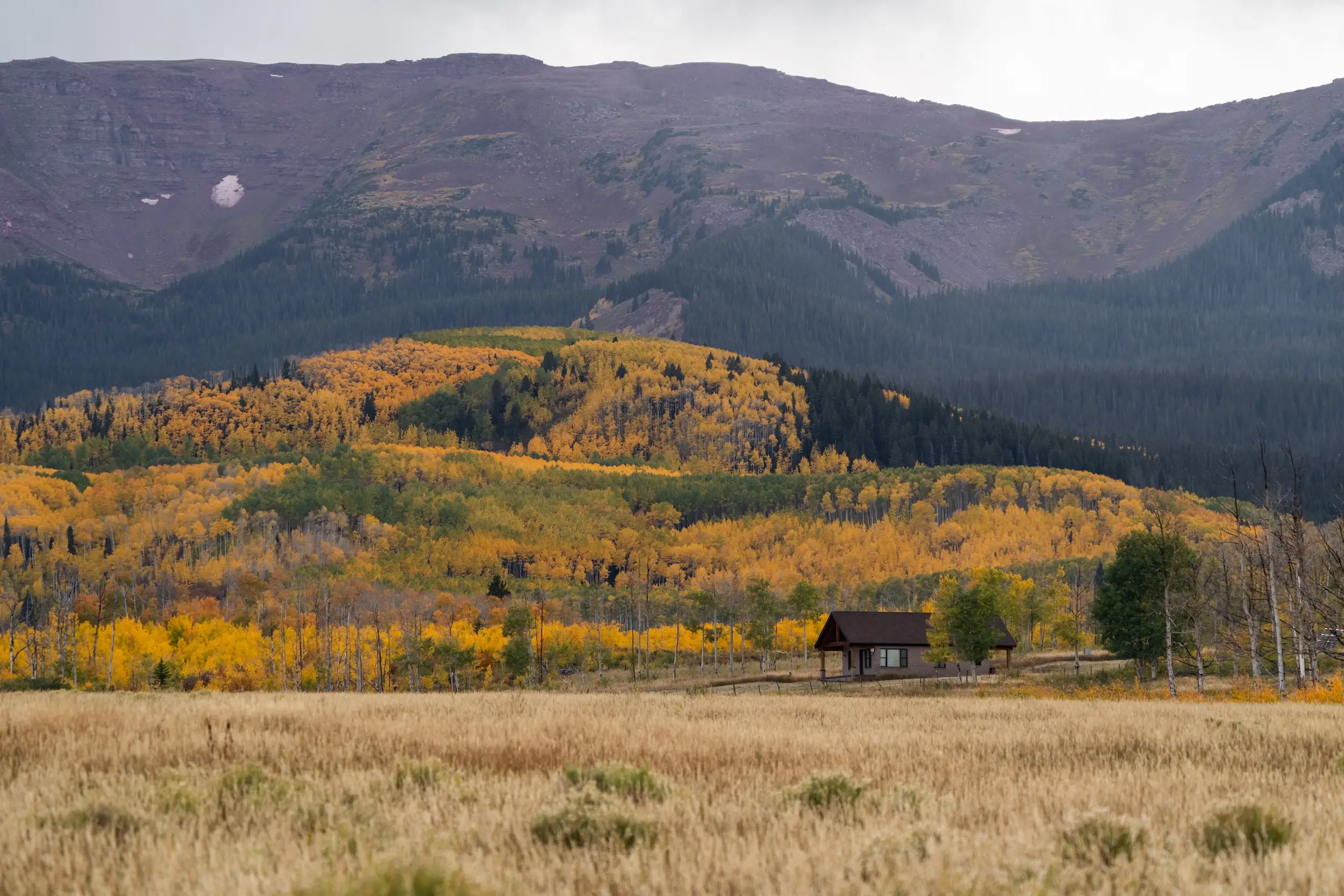 A mountain range with a lone building in the foreground.