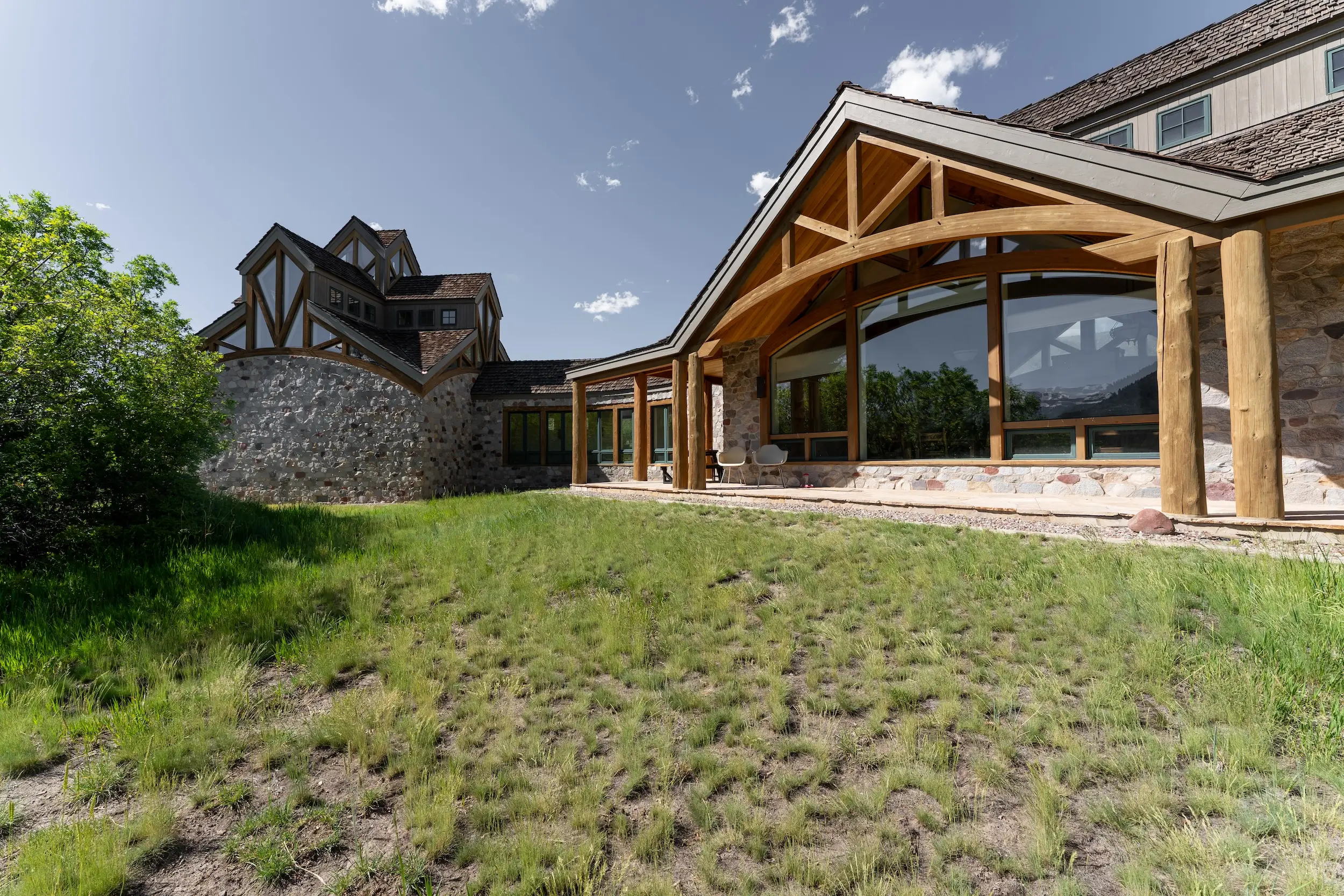 The outside of a building with a large glass window and wooden pillars.