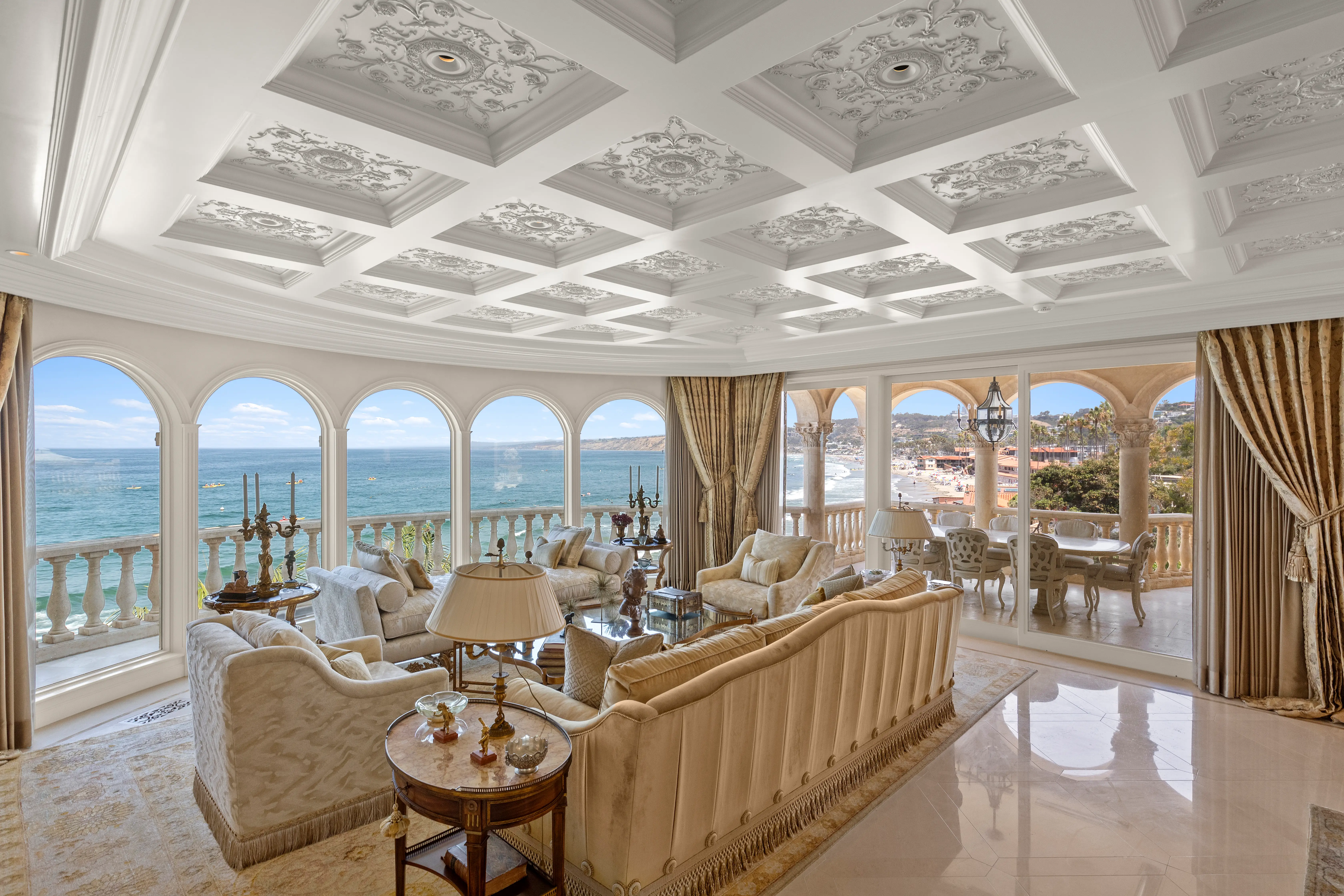 A sitting area overlooking the ocean in the Sand Castle mansion, featuring elaborate molding in the ceiling.