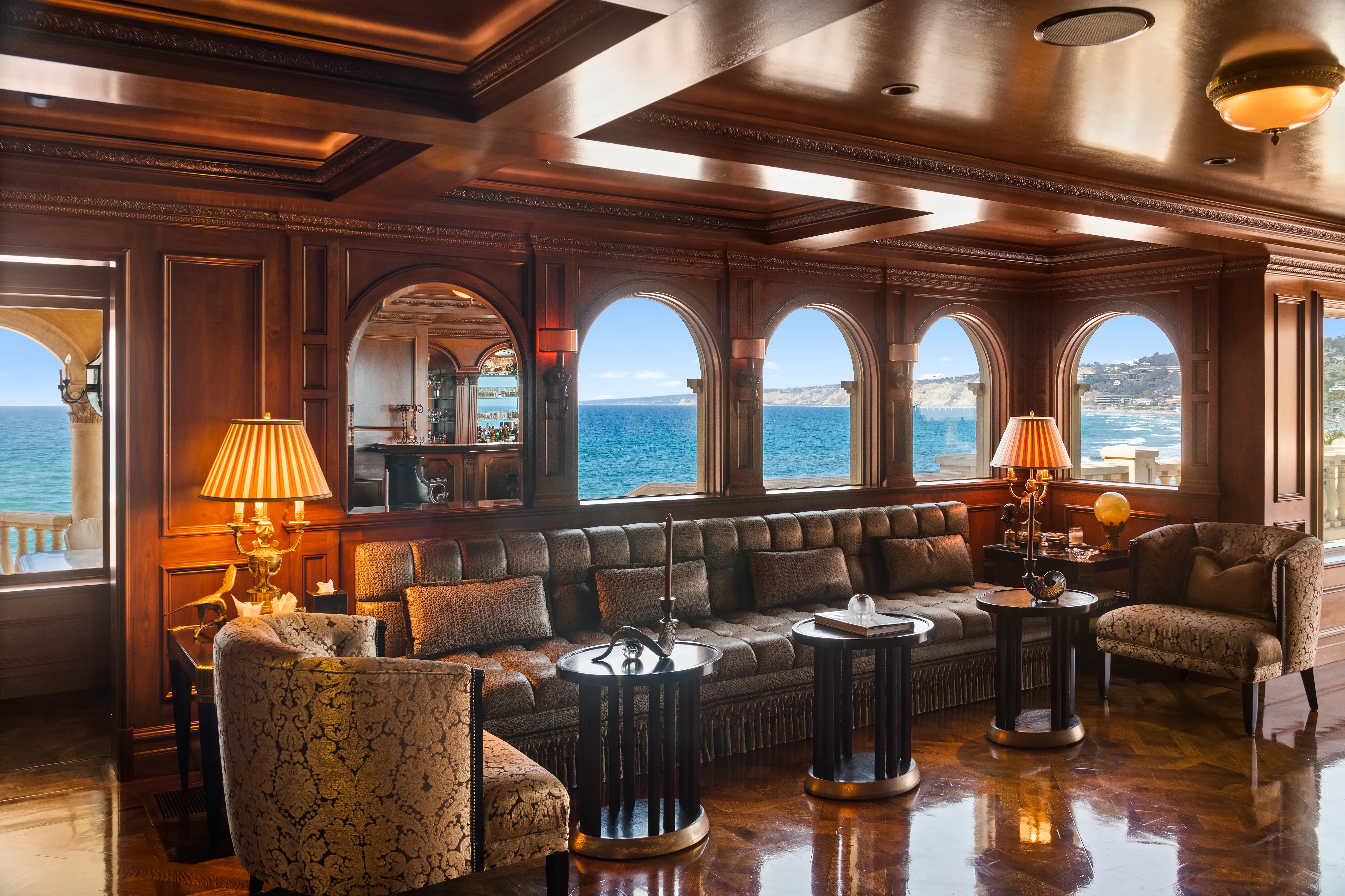 A bar in the Sand Castle mansion, featuring half-moon windows with ocean views.