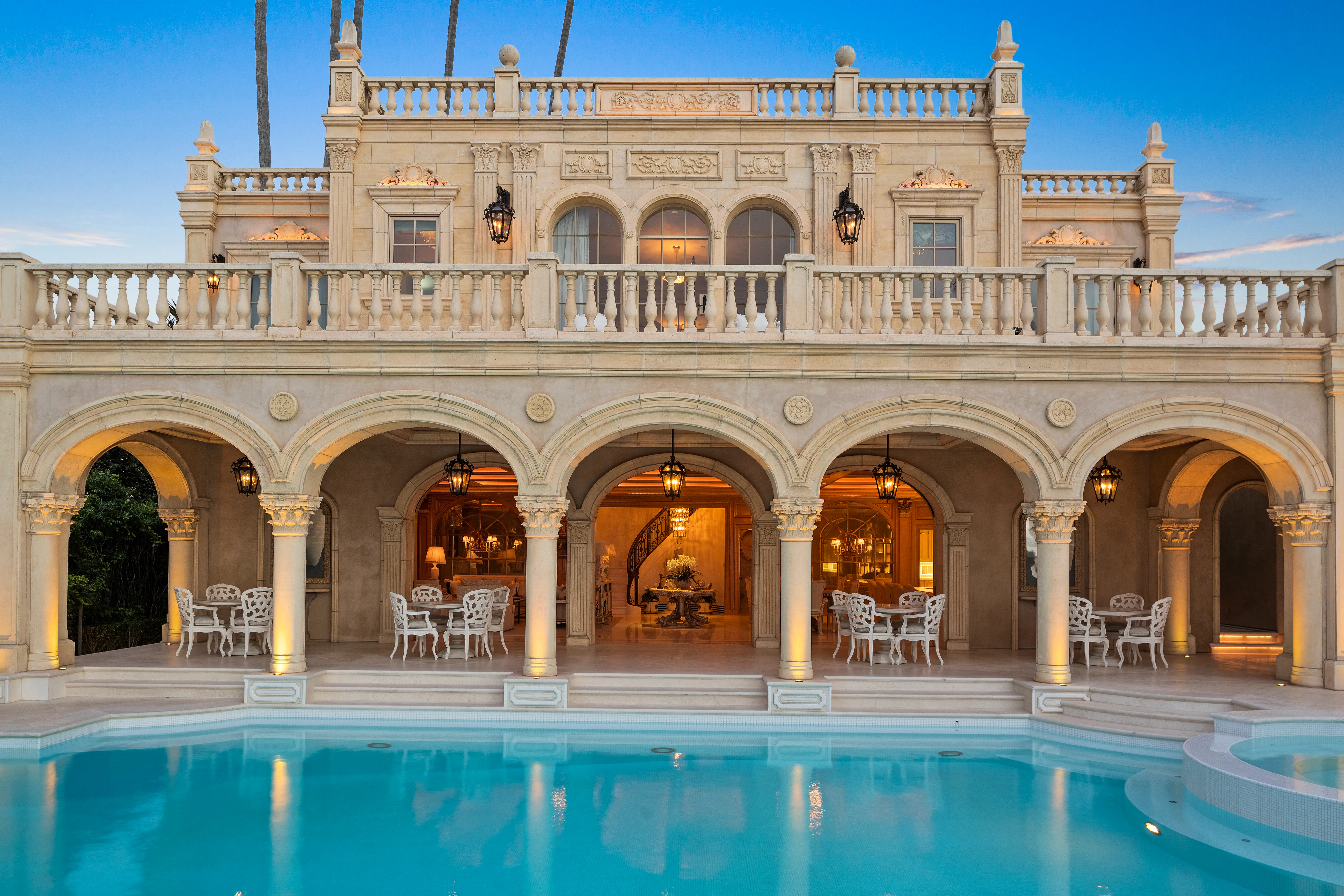 An outdoor view of the terrace and pool of the Sand Castle mansion, with a spiral staircase visible from the outside.