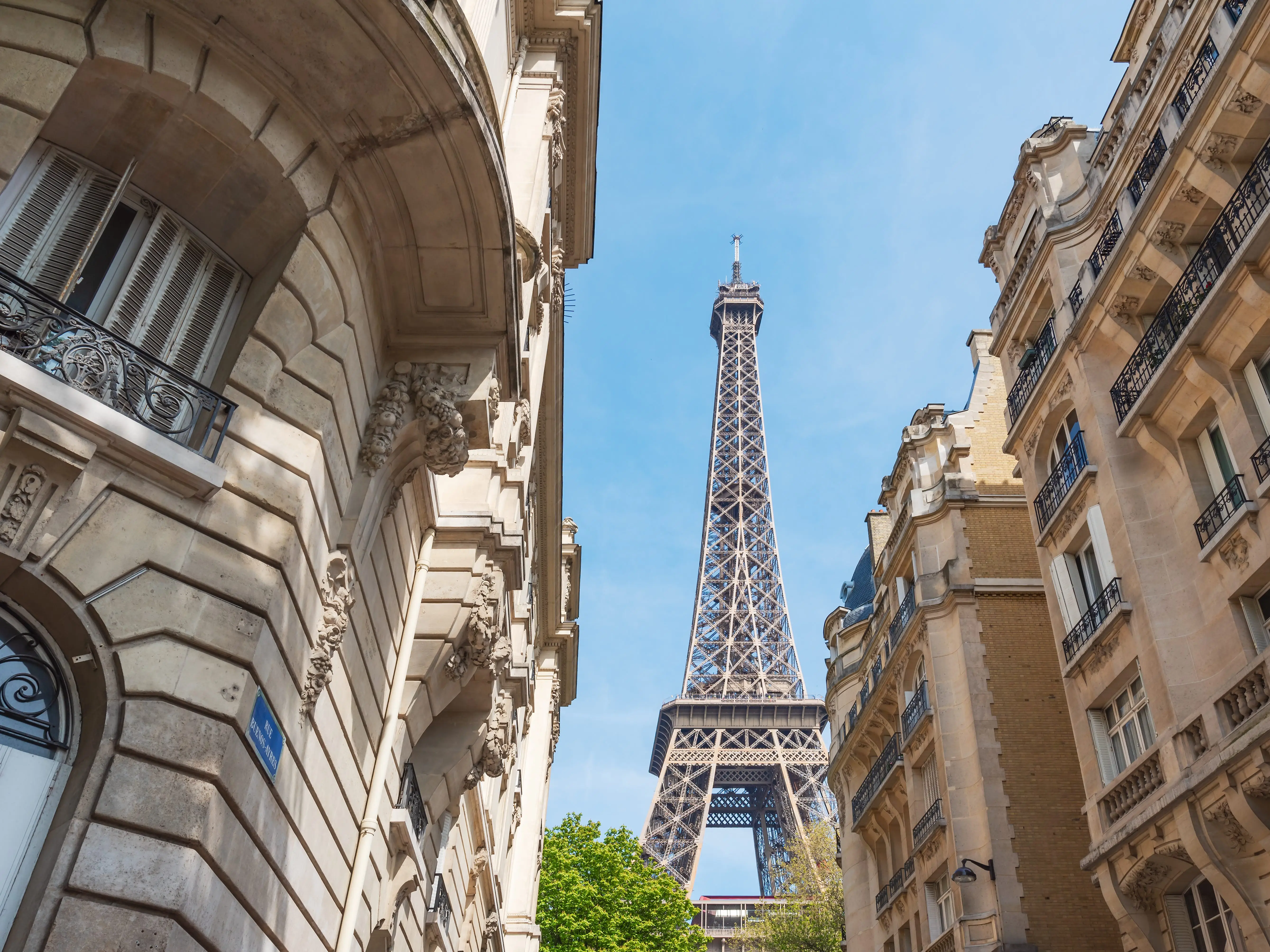 A view of the Eiffel Tower between buildings.
