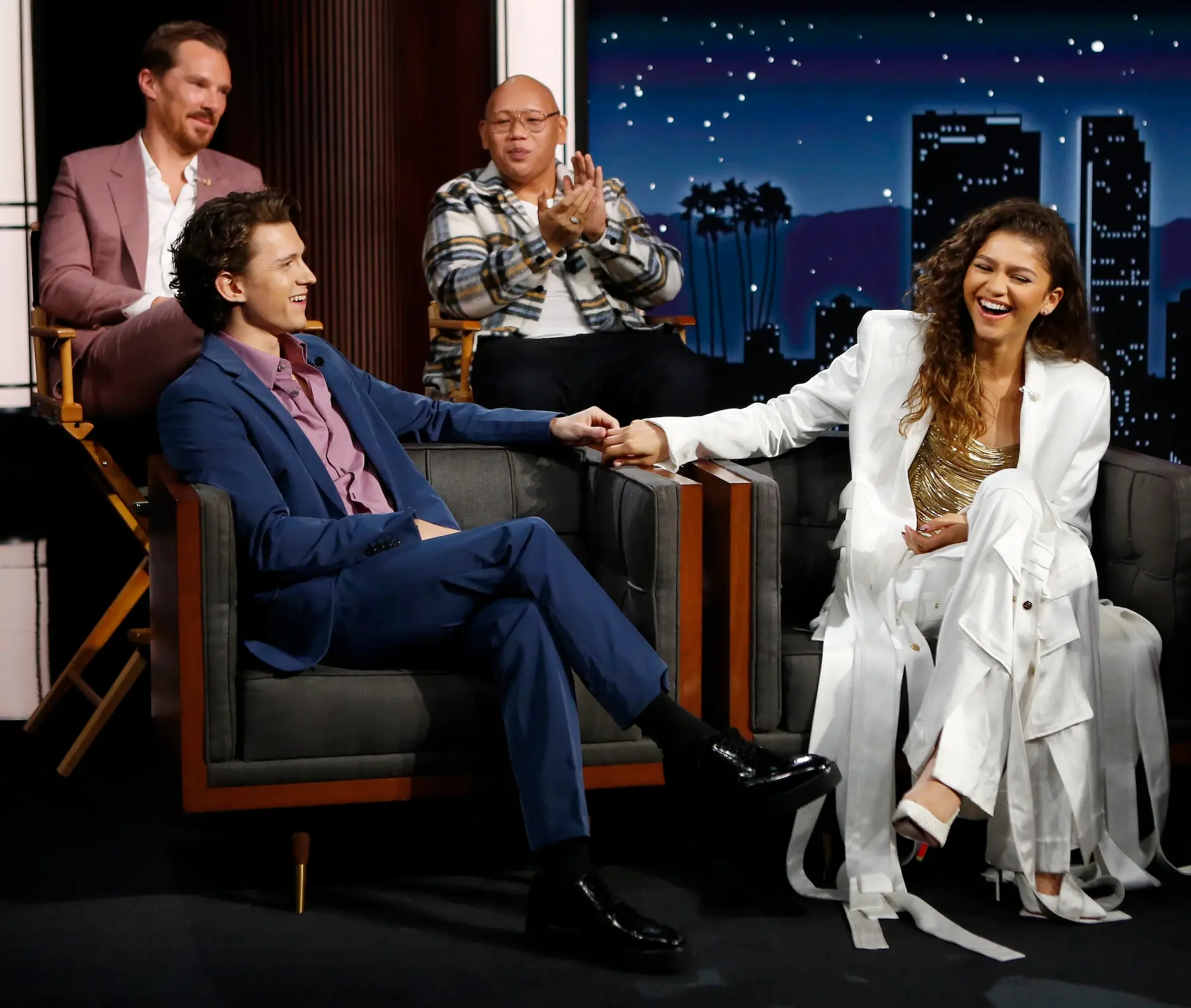 Tom Holland Zendaya laugh on the set of a talk show together.