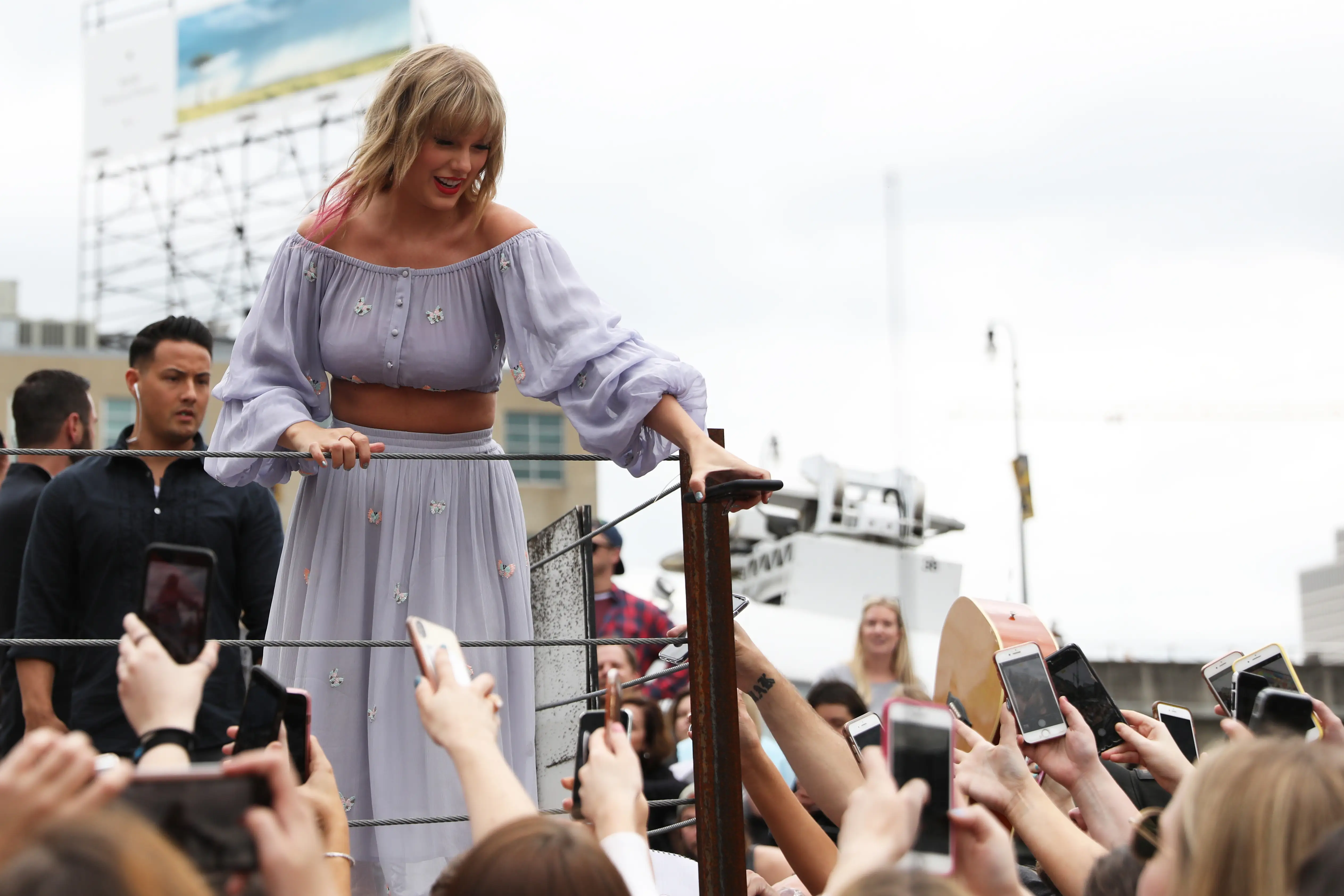 Taylor Swift handing a fan her phone in Nashville