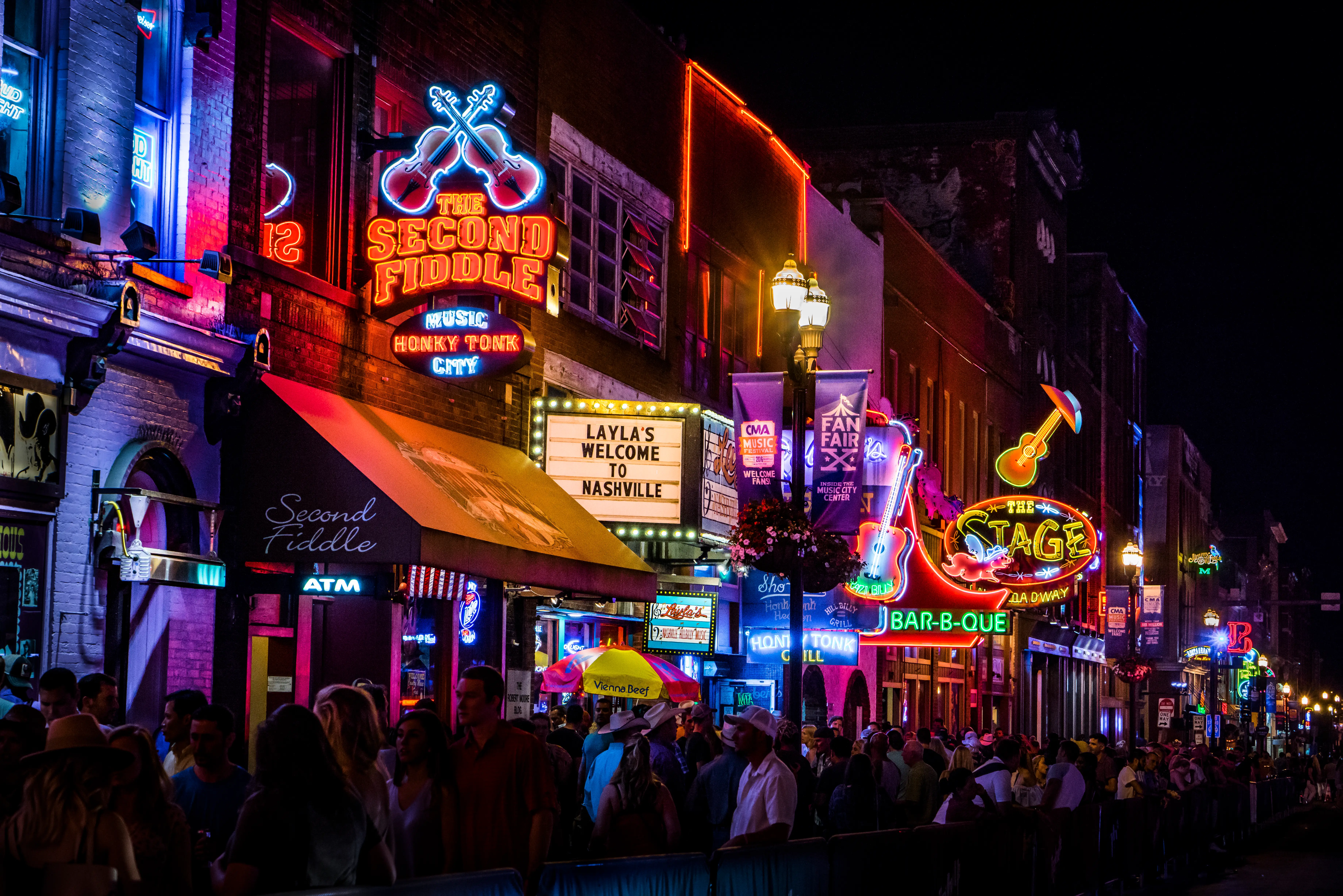 Broadway in Nashville at night with lit-up venues and 