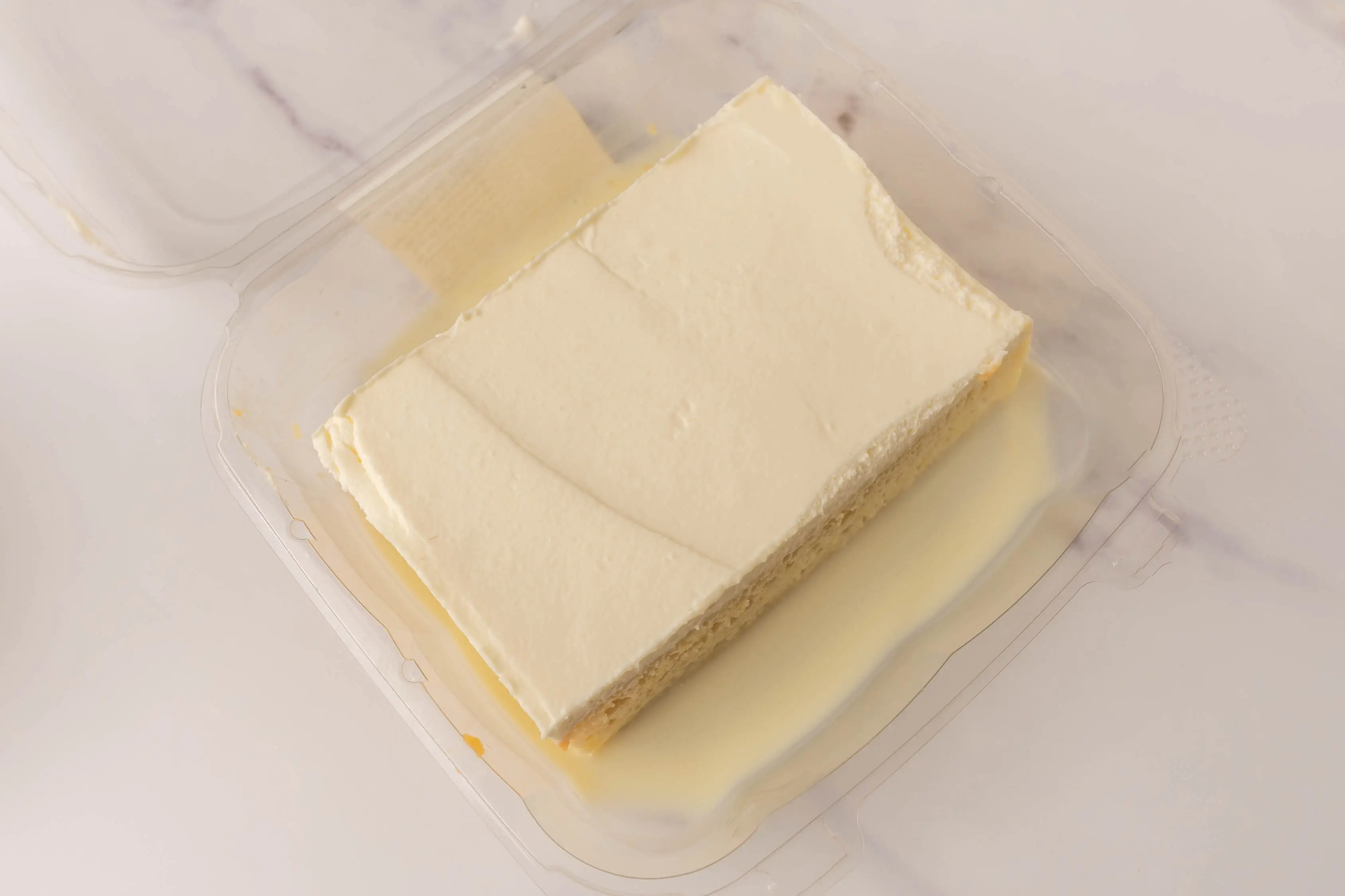 Piece of tres leches from Whole Foods in plastic clamshell container