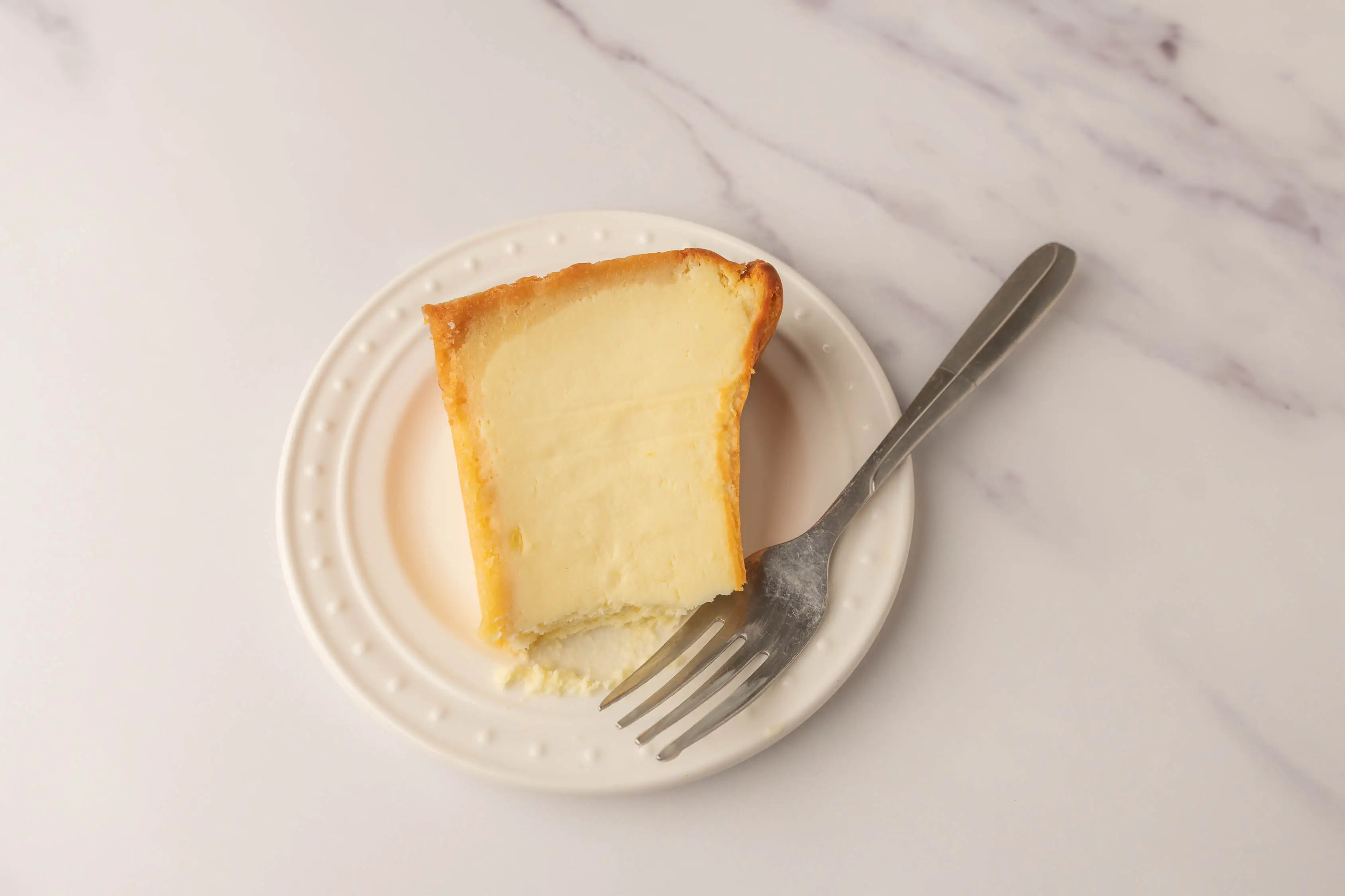 Slice of cheesecake with fork next to it
