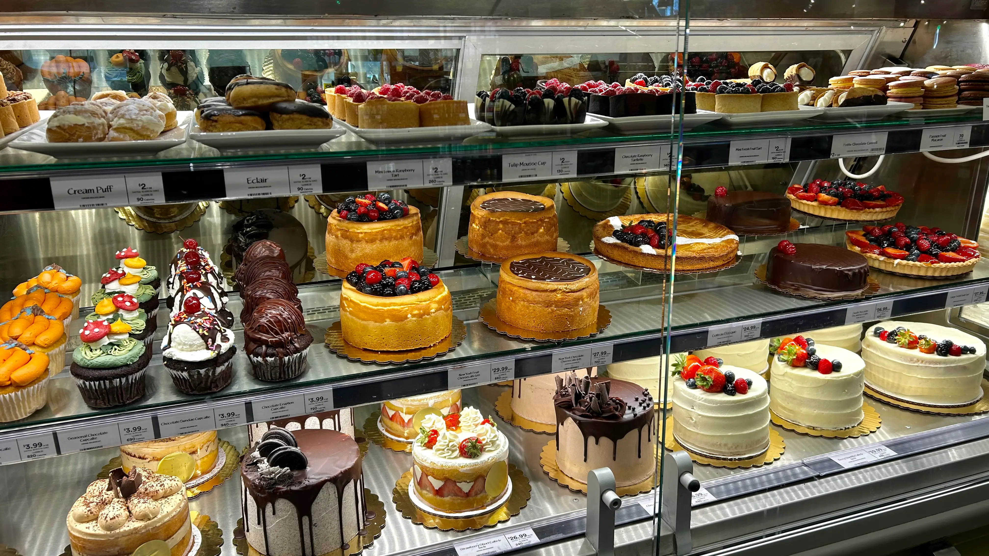 A dessert display case filled with cakes and other baked goods.
