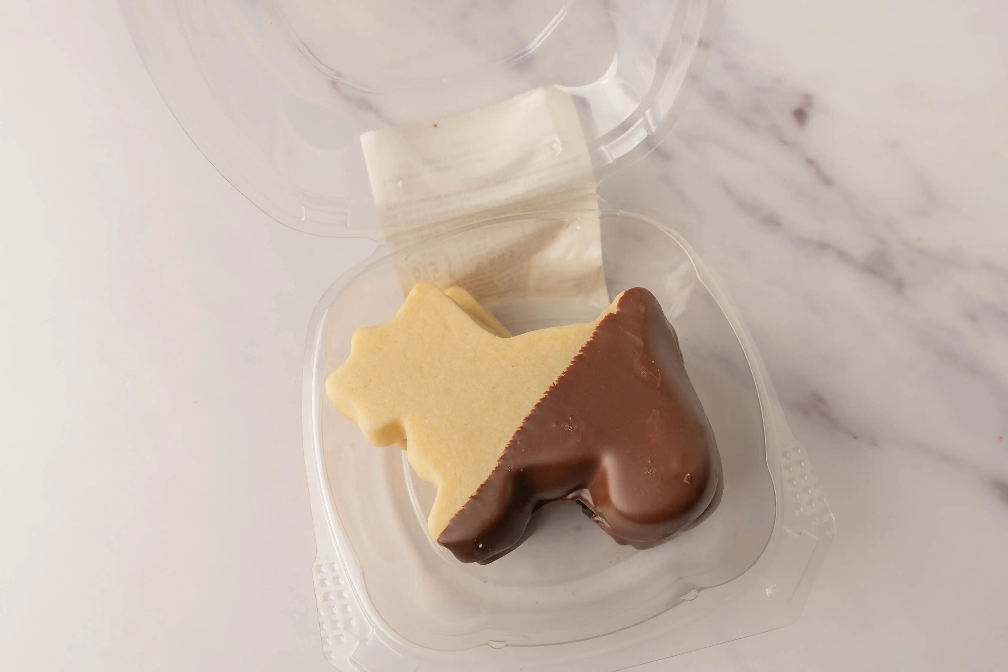 Dog-shaped shortbread cookie with bottom half dipped in chocolate from WholeFoods
