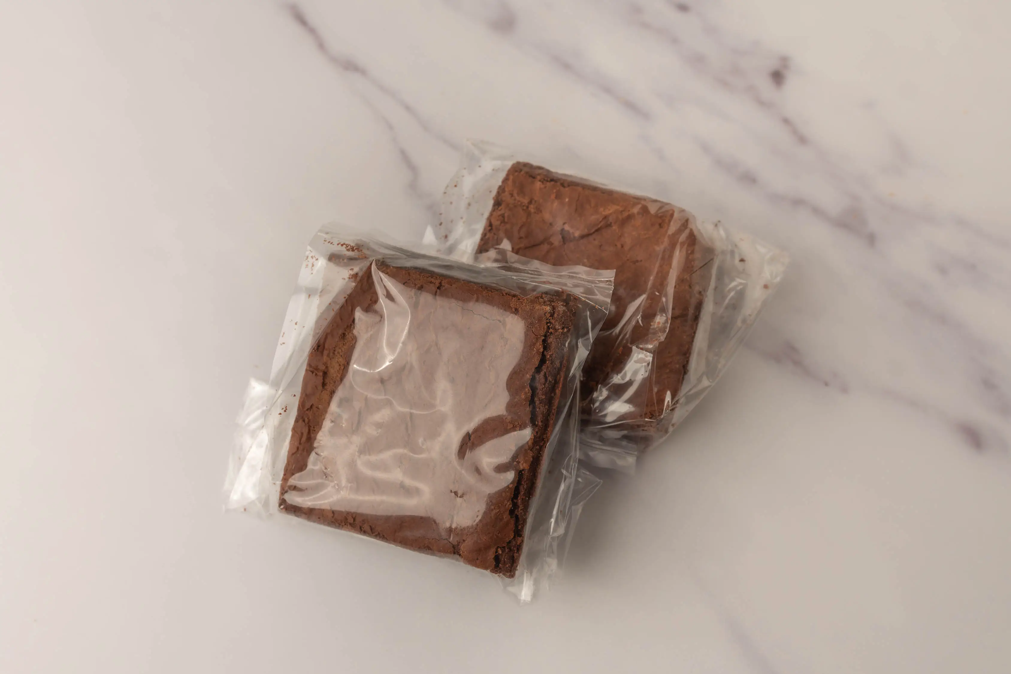 Two brownies from Whole foods in plastic wrappers