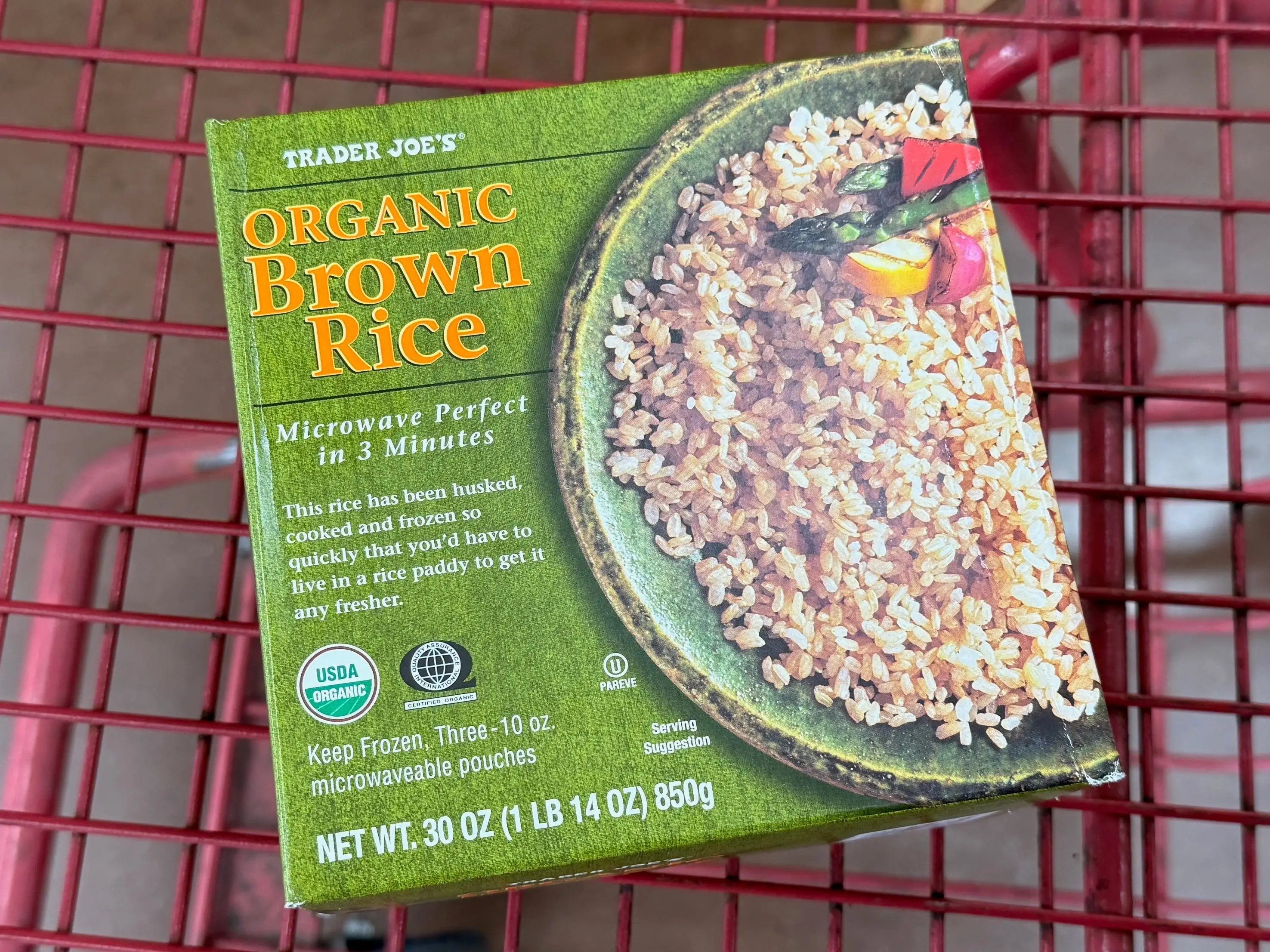 box of frozen brown rice in a cart at trader joe's