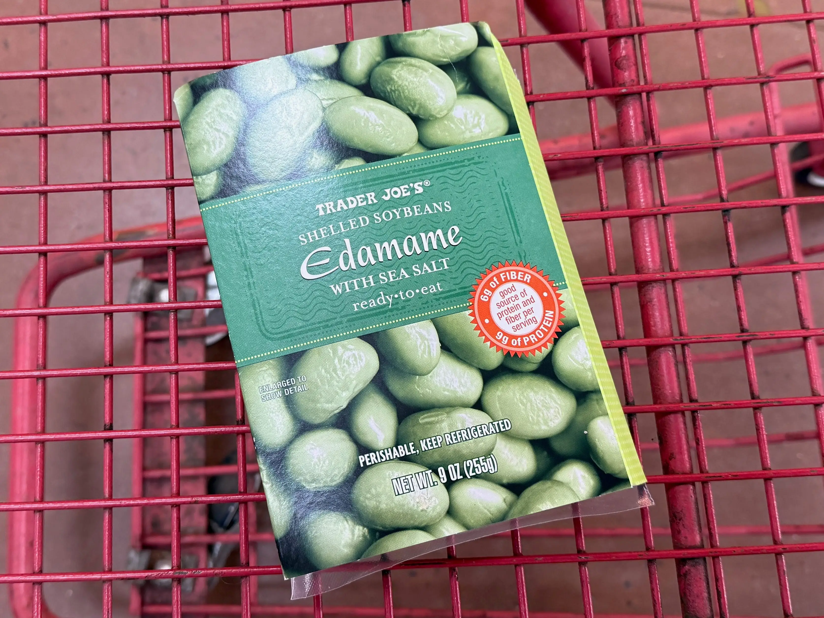 box of shelled edamame in a cart at trader joe's