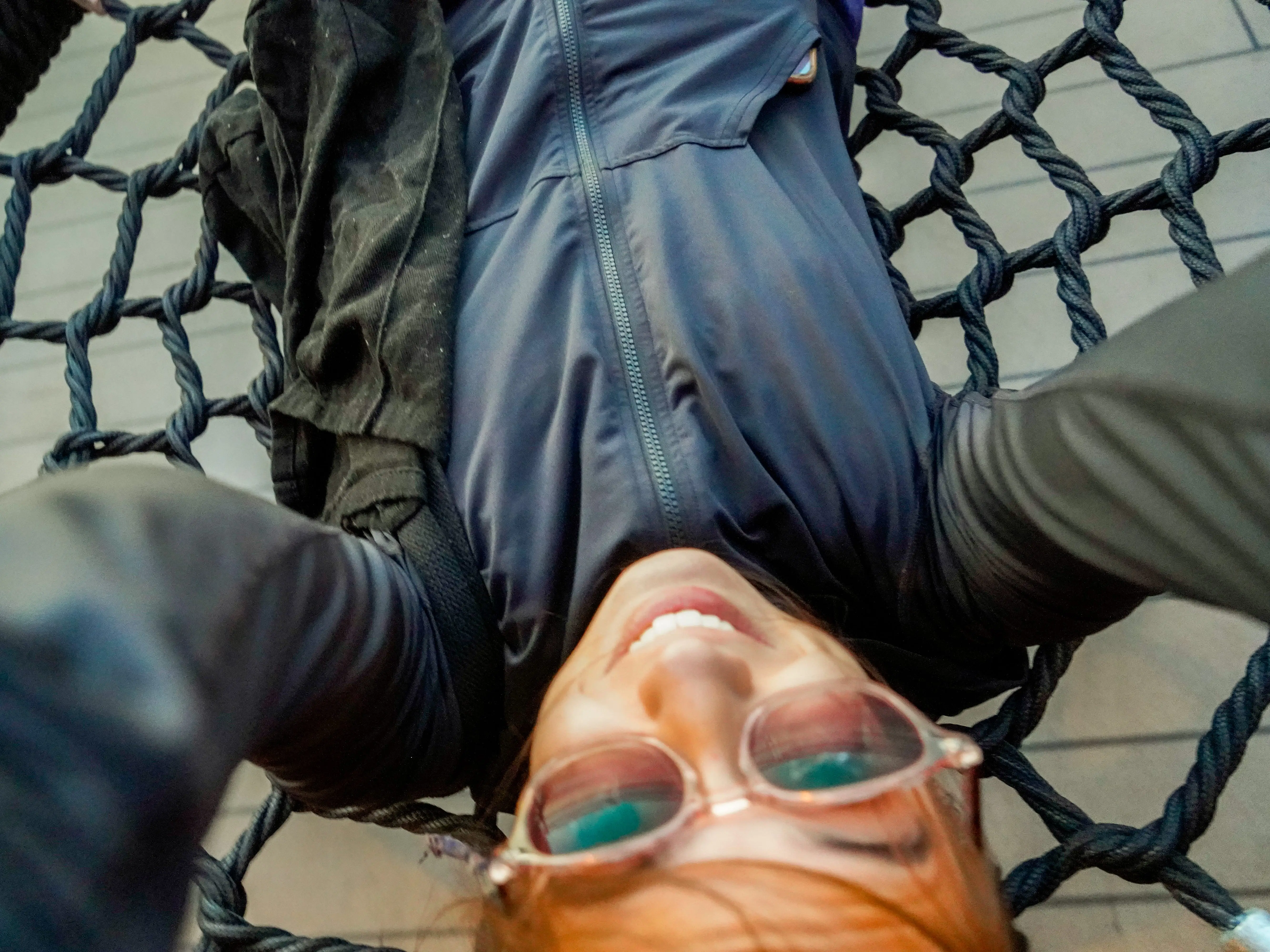 An aerial view of the author smiling on a large, netted swing
