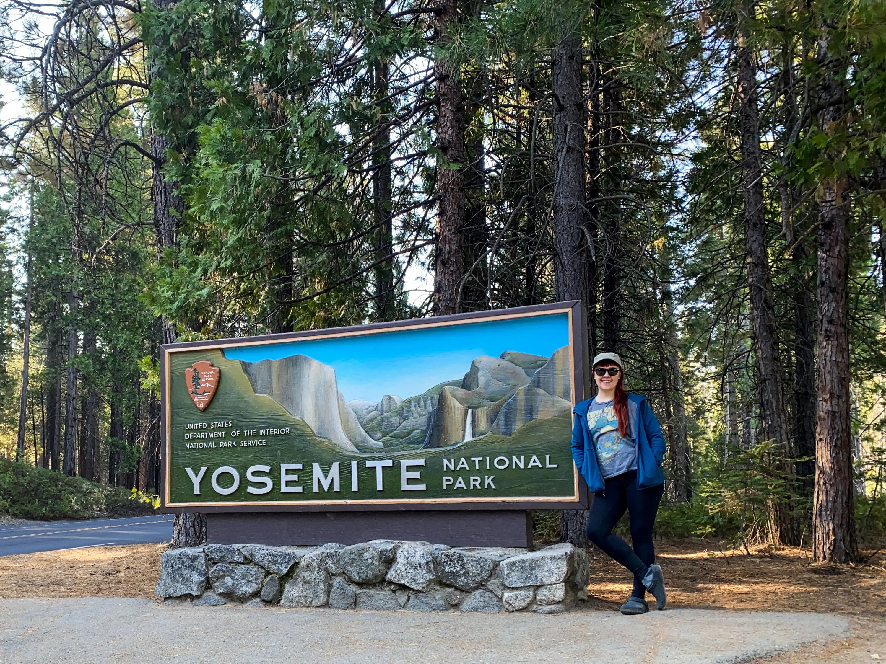 Author Emily Pennington smiling with Yosemite national park sign