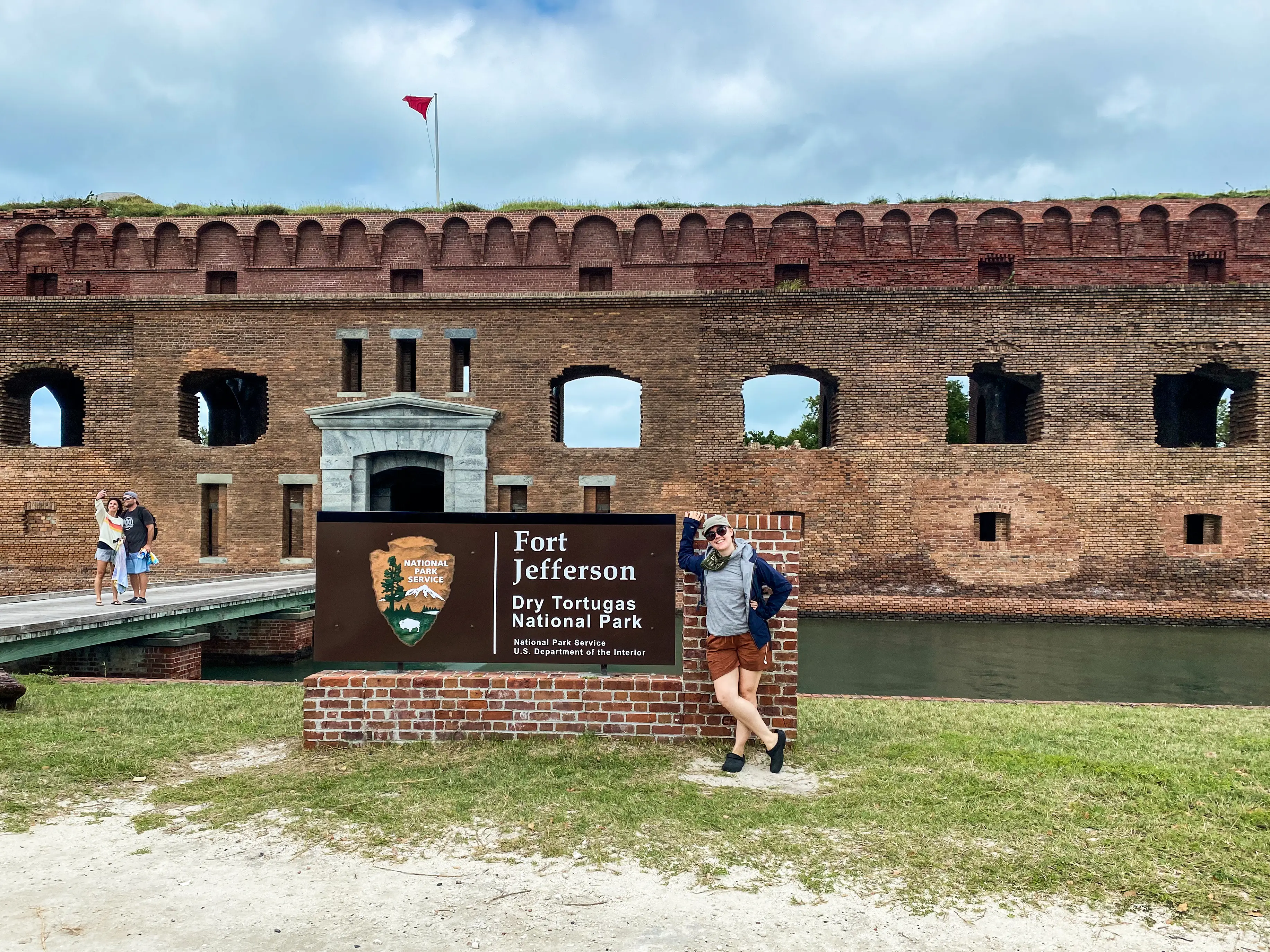 Emily Pennington leaning on Fort Jefferson Dry Tortugas National Park sign