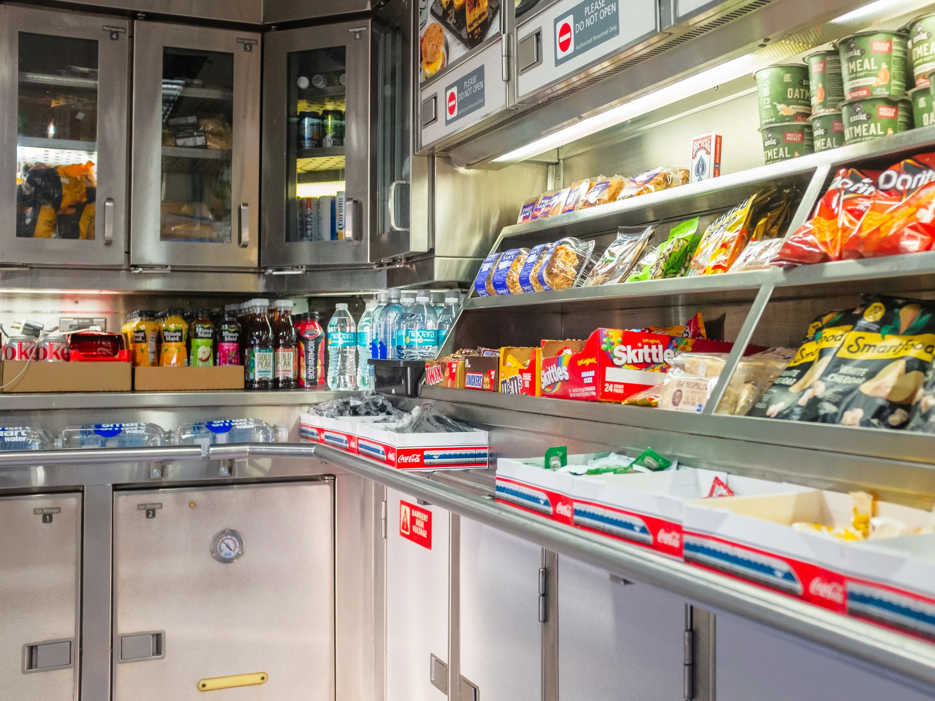 Inside a cafe car on a train, with beverages on the left and snacks on the right