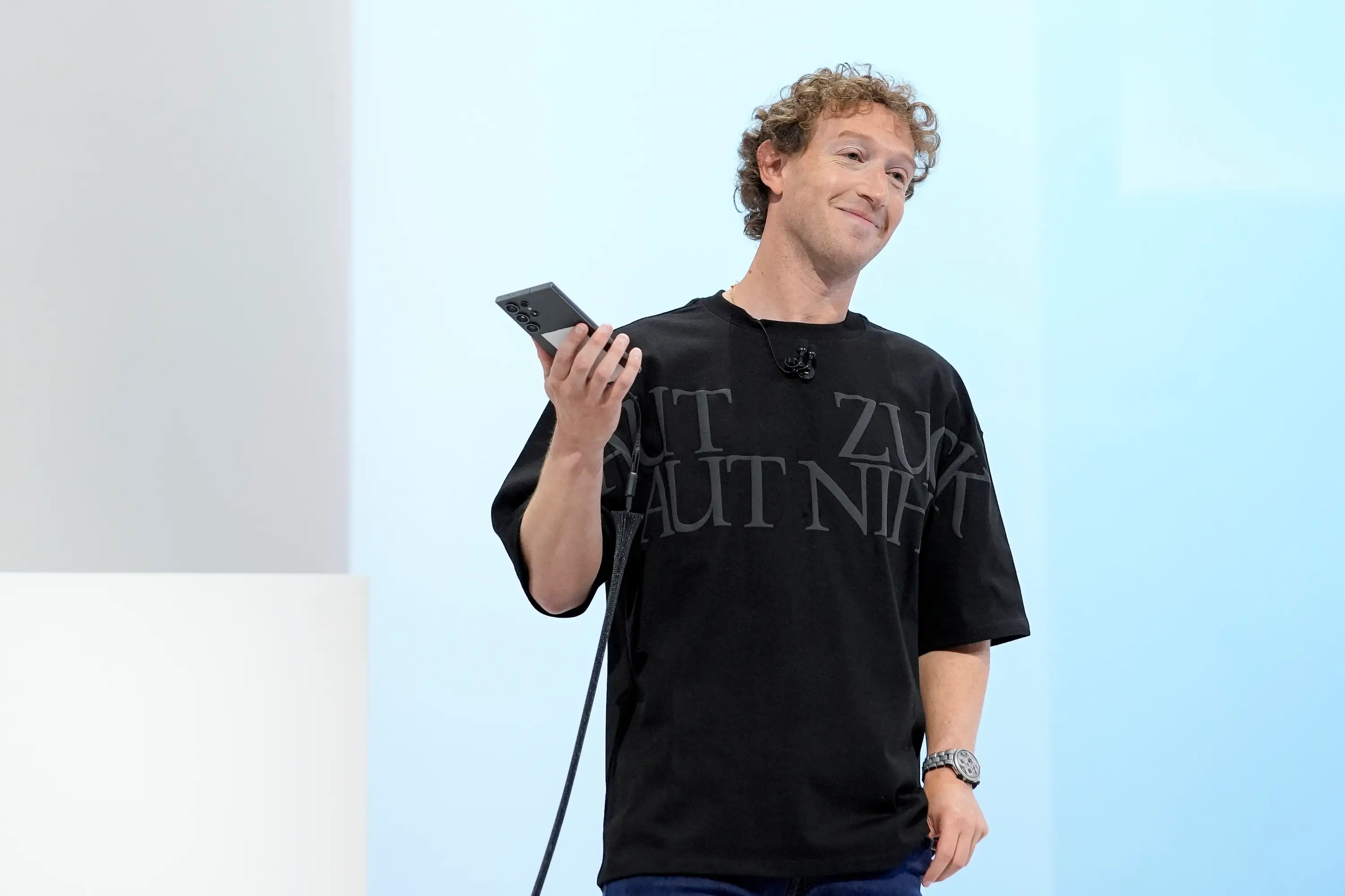 Mark Zuckerberg holds a phone and wears a F.P.Journe watch.