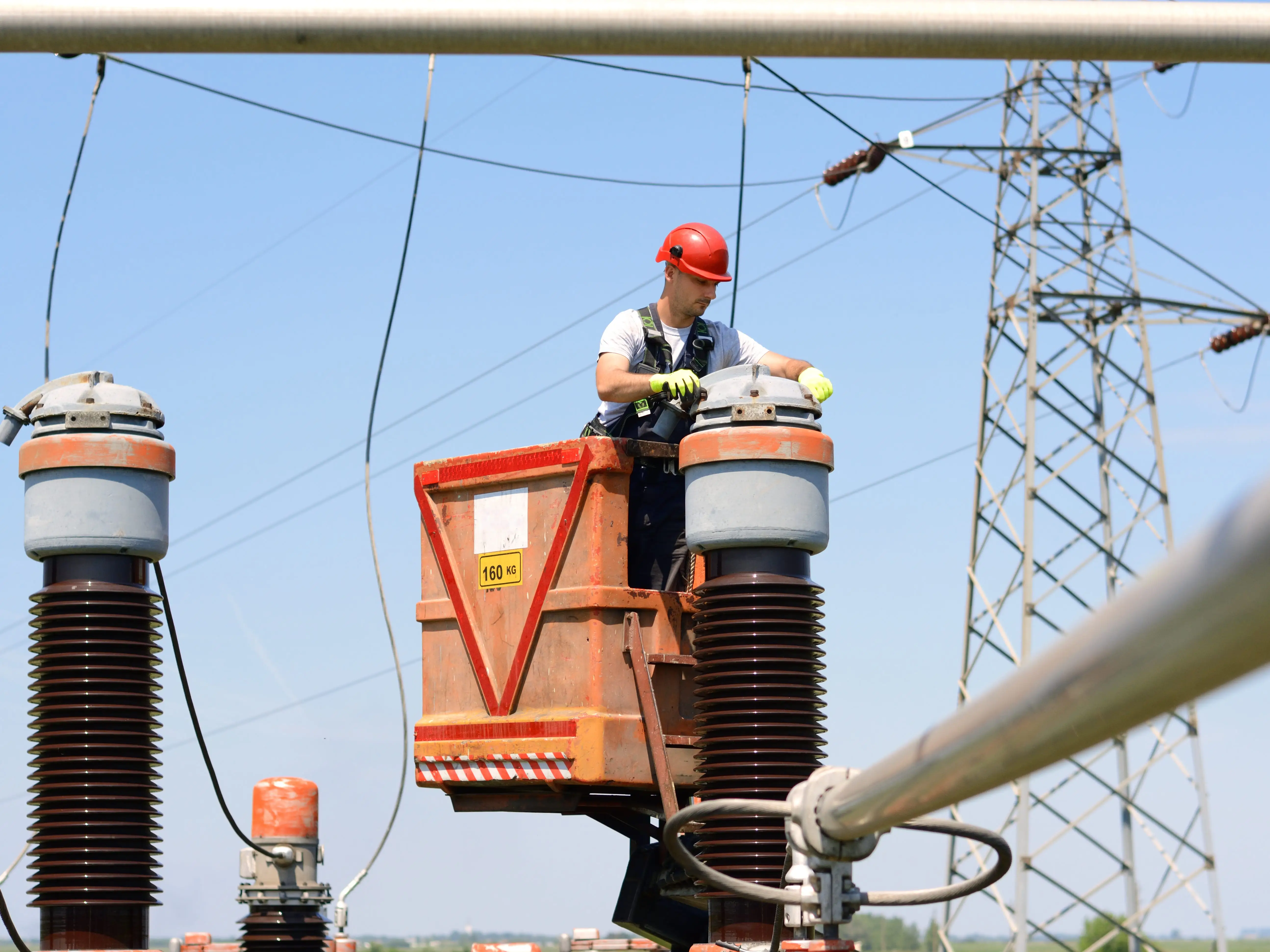 A worker fixing power lines in power substation