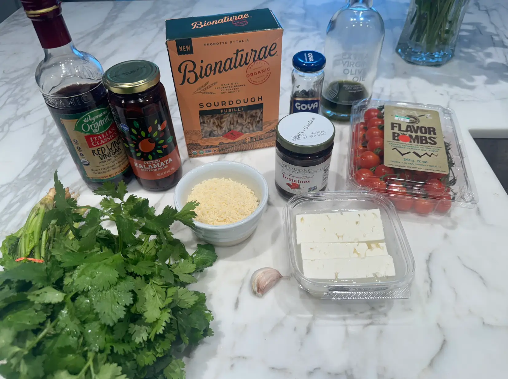 All the ingredients you'll need to make Ina Garten's pasta salad, including wine vinegar, fusilli, Parmesan, feta, and tomatoes.