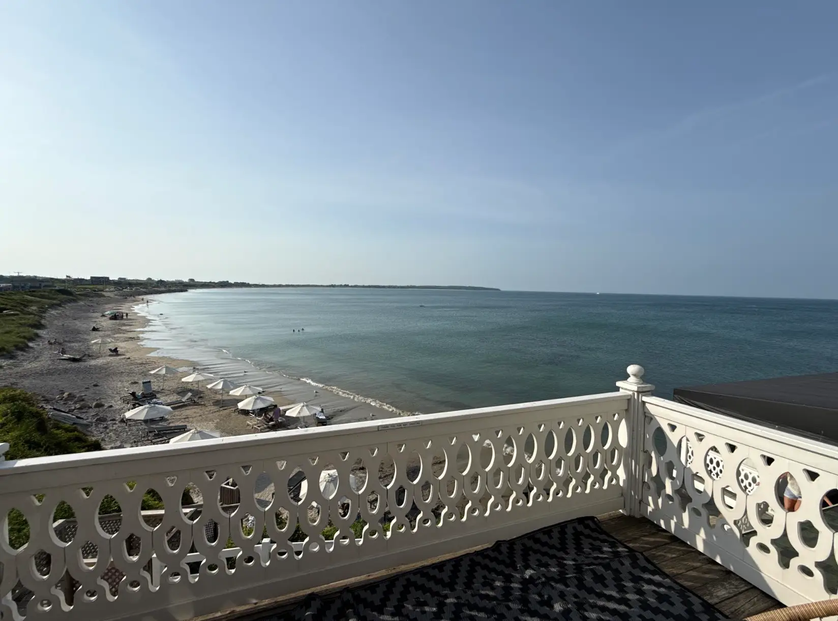 A view of a beach from a restaurant porch.
