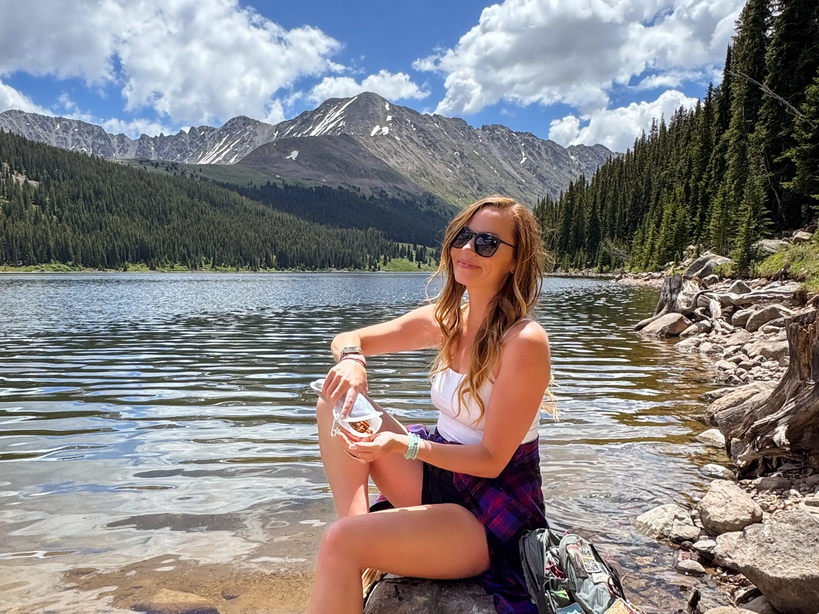 Emily sitting on a rock eating a snack.