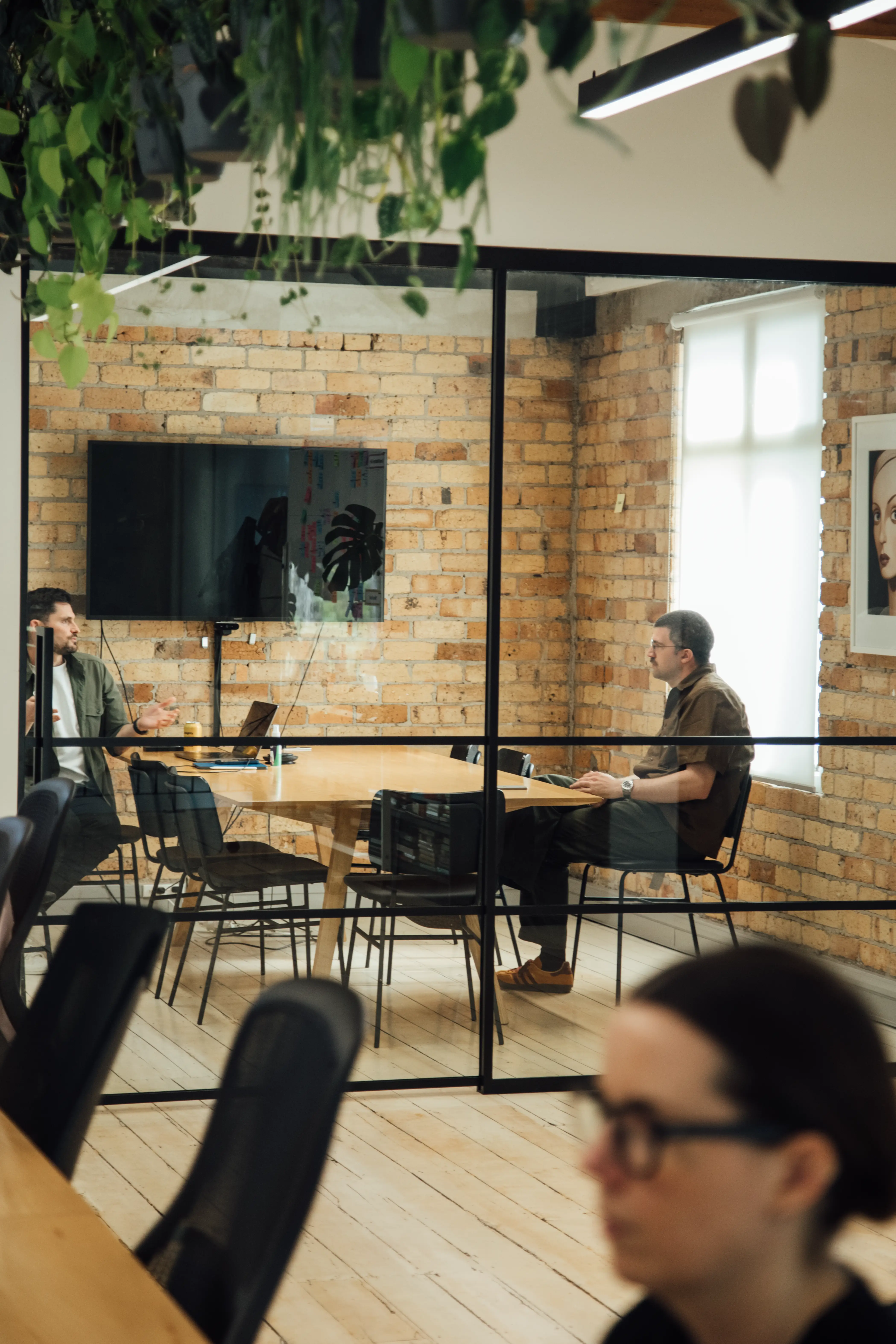 Workers in a conference room in Previously Unavailable's office space.