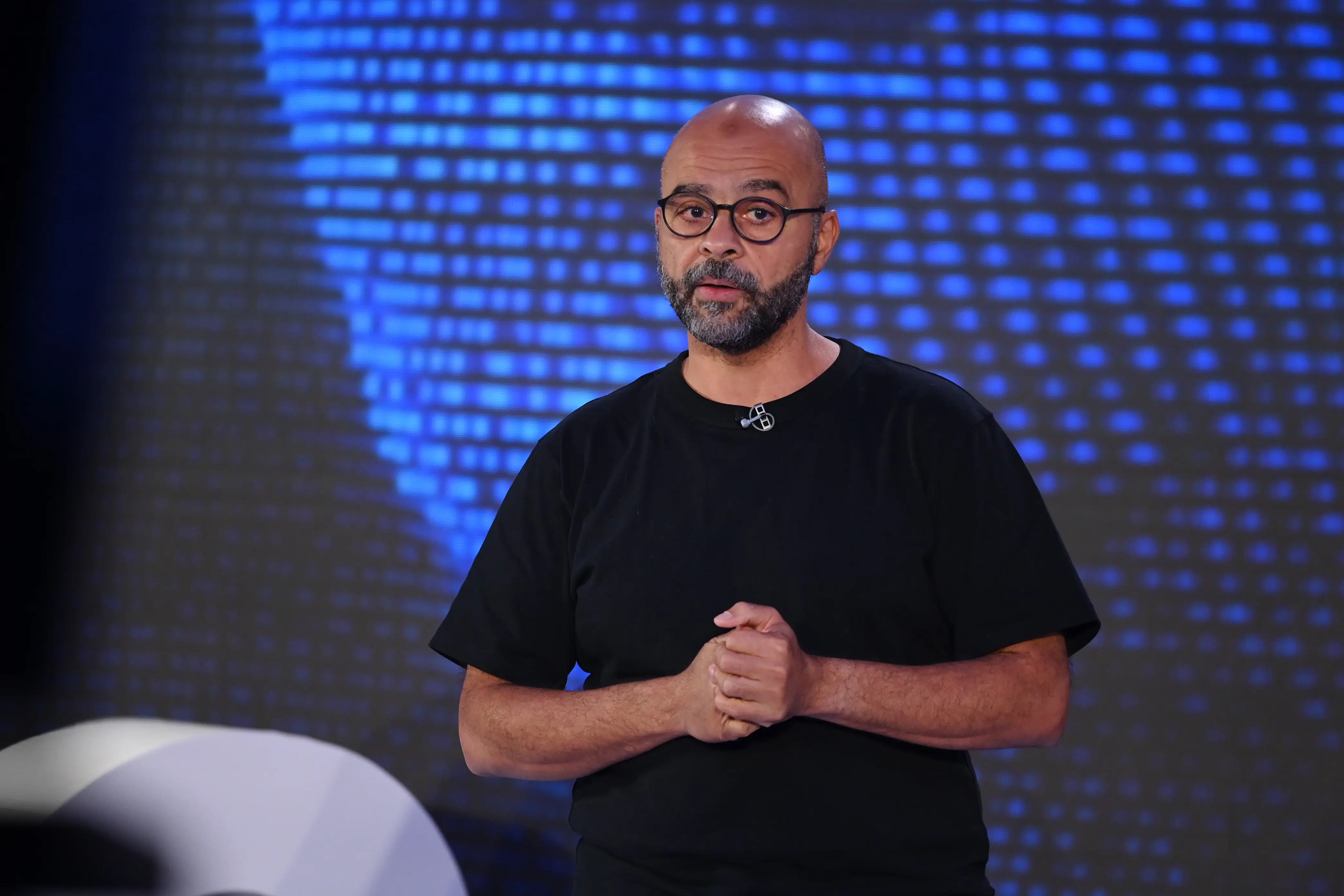 Mo Gawdat in black t-shirt on stage.