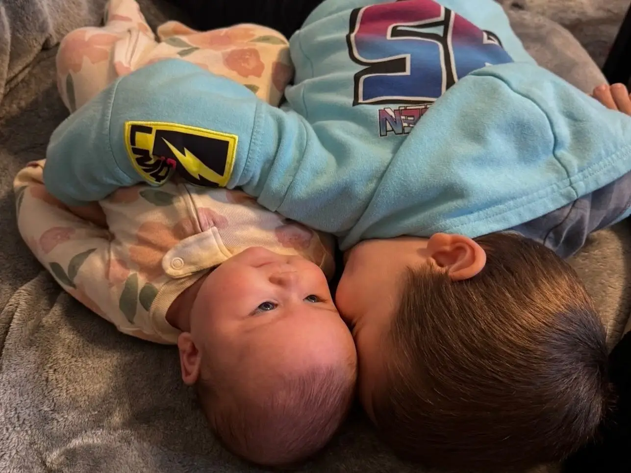 Toddler hugging baby
