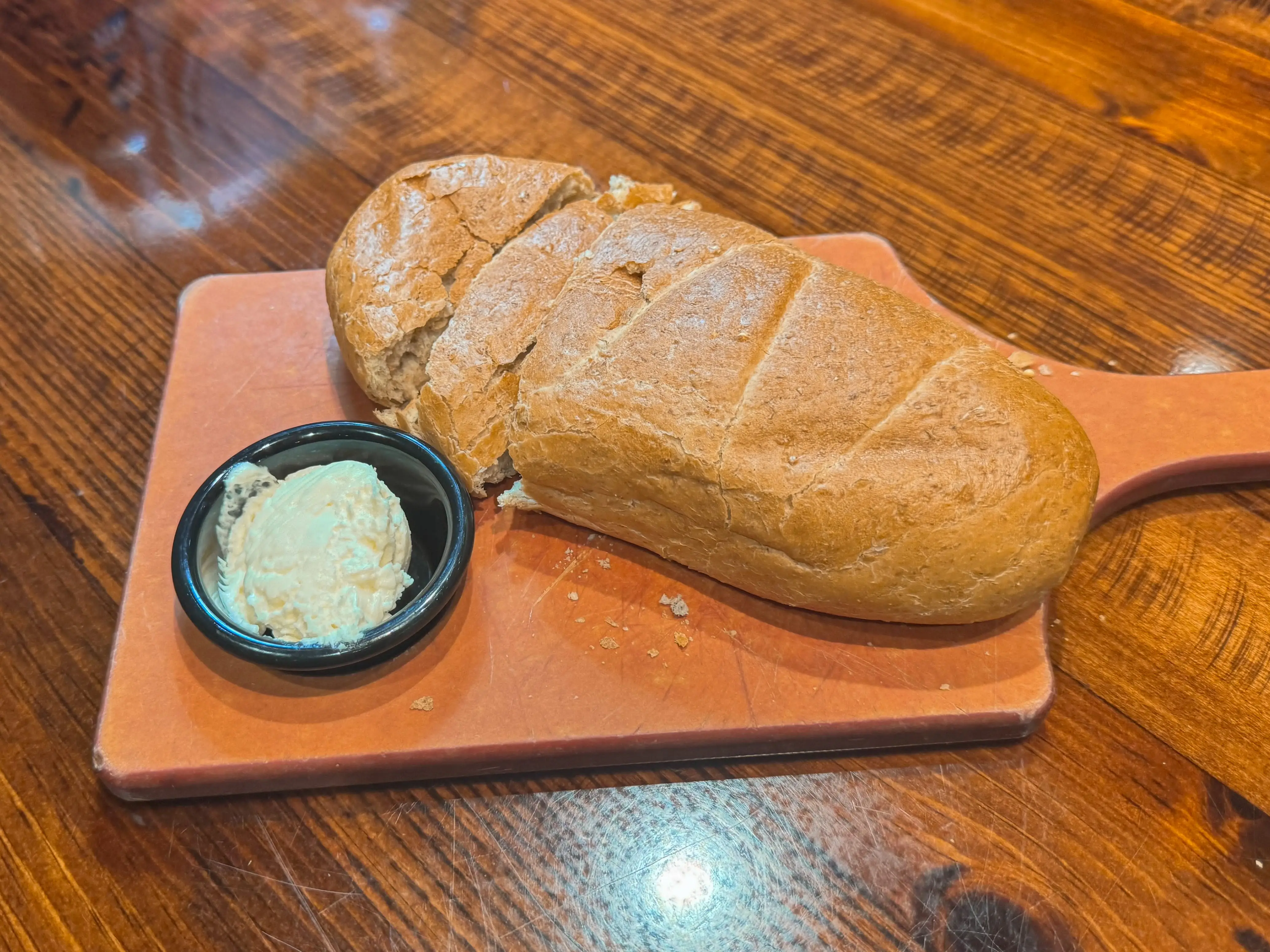 Bread and butter on a cutting board.